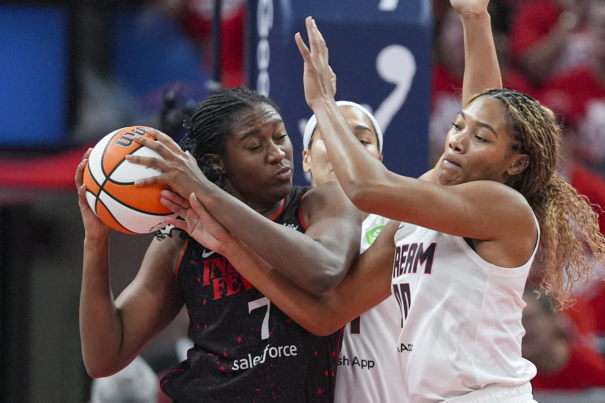 Indiana Fever forward Aliyah Boston (7) get tied up with Atlanta Dream forward Naz Hillmon (0) in the first half of a WNBA basketball playoff game in Indianapolis, Tuesday, Sept. 16, 2025.