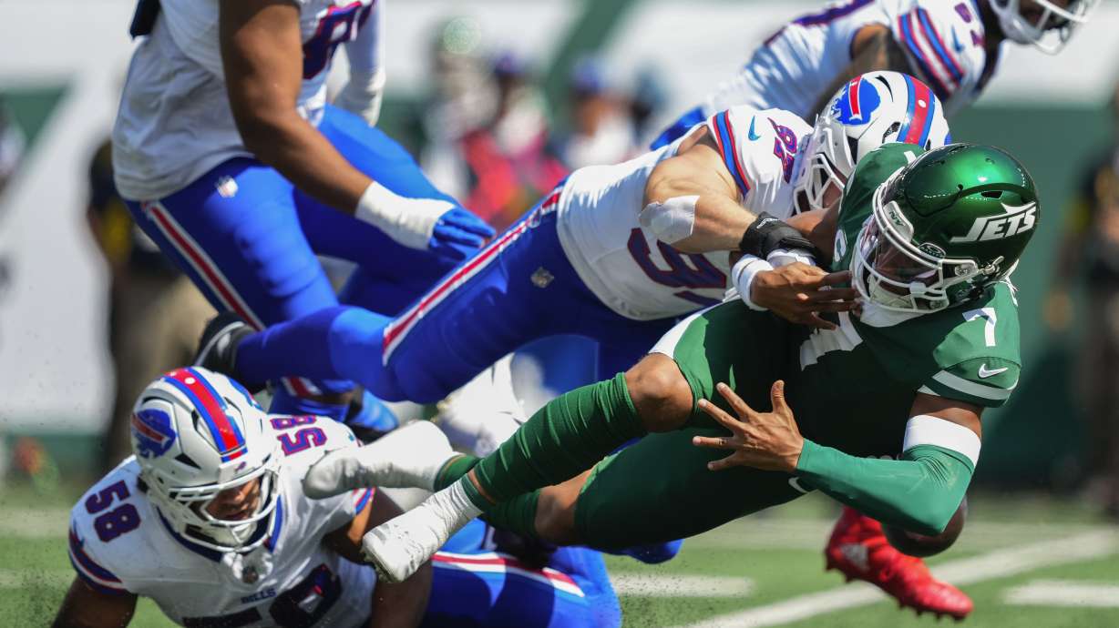 New York Jets quarterback Justin Fields (7) fumbles the ball as he's tackled by Buffalo Bills linebacker Matt Milano (58) and defensive end Joey Bosa (97) during the first quarter of an NFL football game, Sunday, Sept. 14, 2025, in East Rutherford, N.J.