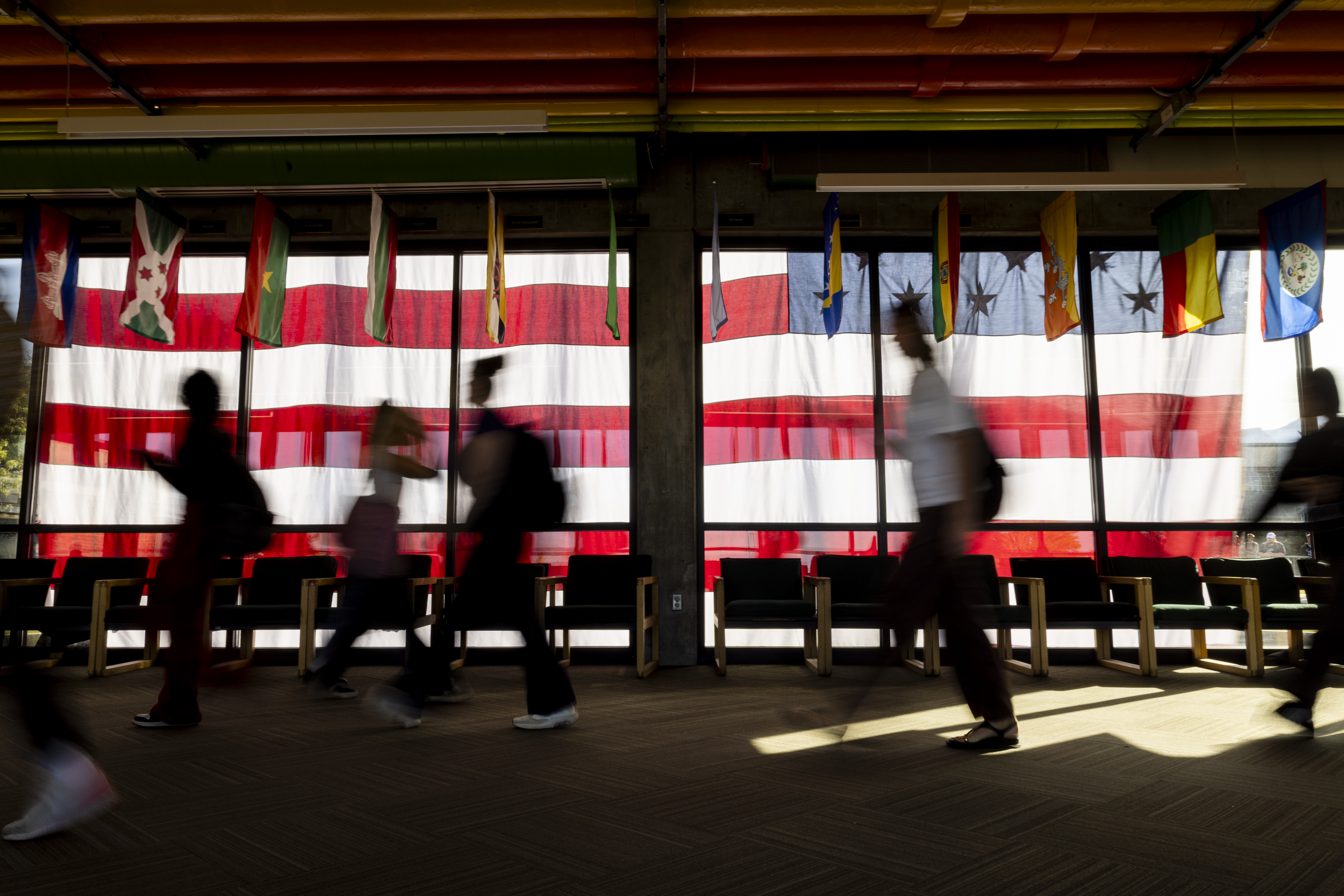 Students walk through the Hall of Flags and by a flag hanging where Charlie Kirk was shot a week earlier on the campus of Utah Valley University in Orem on Wednesday.
