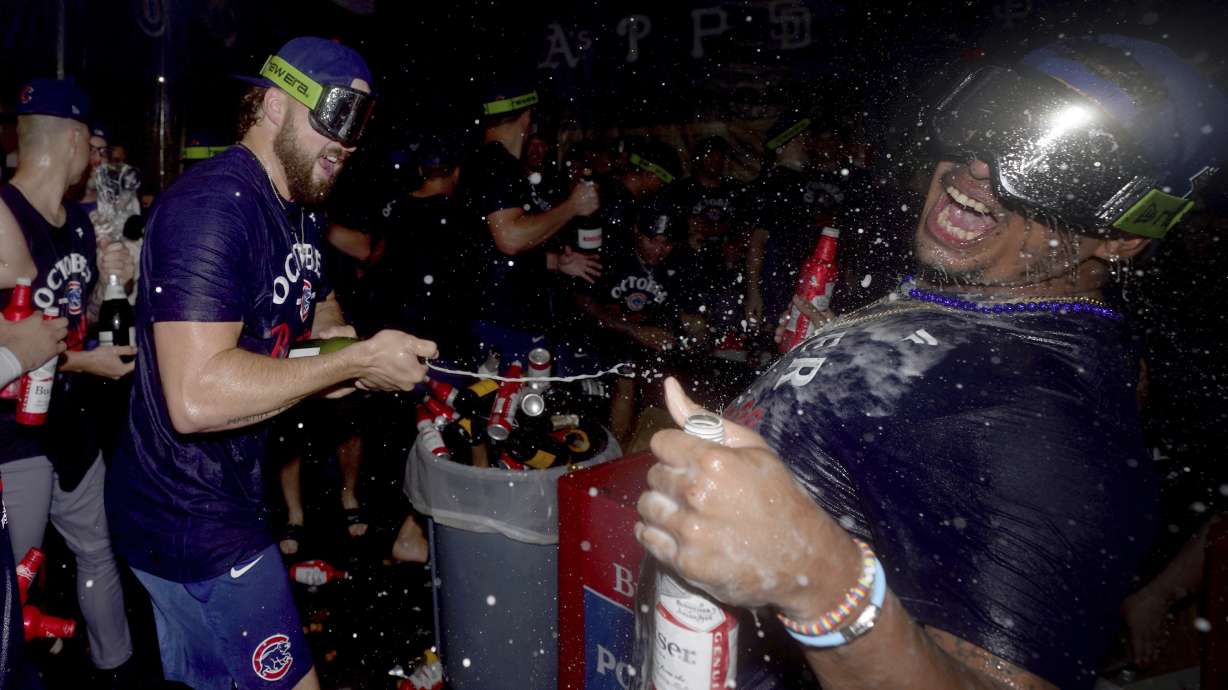 Chicago Cubs' Porter Hodge, left, celebrates with Daniel Palencia, right, in the clubhouse after the Cubs clinched a playoff berth after defeating the Pittsburgh Pirates in a baseball game Wednesday, Sept. 17, 2025, in Pittsburgh.