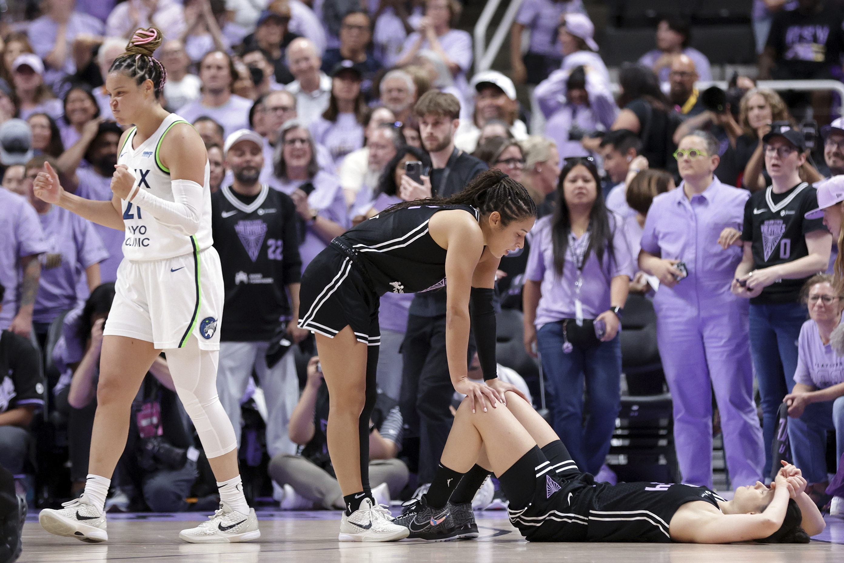 Golden State Valkyries' Veronica Burton, center, consoles Cecilia Zandalasini, bottom right, after Zandalasini missed a game-winning shot at the buzzer as Minnesota Lynx' Kayla McBride, left, celebrates their team's win in Game 2 in the first round of the WNBA basketball playoffs Wednesday, Sept. 17, 2025, in San Jose, Calif. 