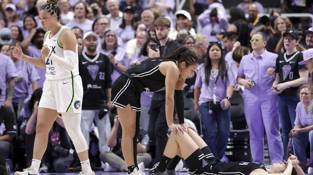 Golden State Valkyries' Veronica Burton, center, consoles Cecilia Zandalasini, bottom right, after Zandalasini missed a game-winning shot at the buzzer as Minnesota Lynx' Kayla McBride, left, celebrates their team's win in Game 2 in the first round of the WNBA basketball playoffs Wednesday, Sept. 17, 2025, in San Jose, Calif.