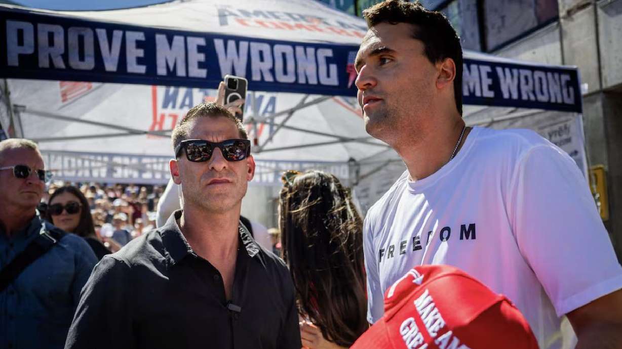 Charlie Kirk’s security guard stands by as Kirk hands out hats before Kirk is fatally shot during Turning Point USA’s visit to Utah Valley University in Orem on Sept. 10.