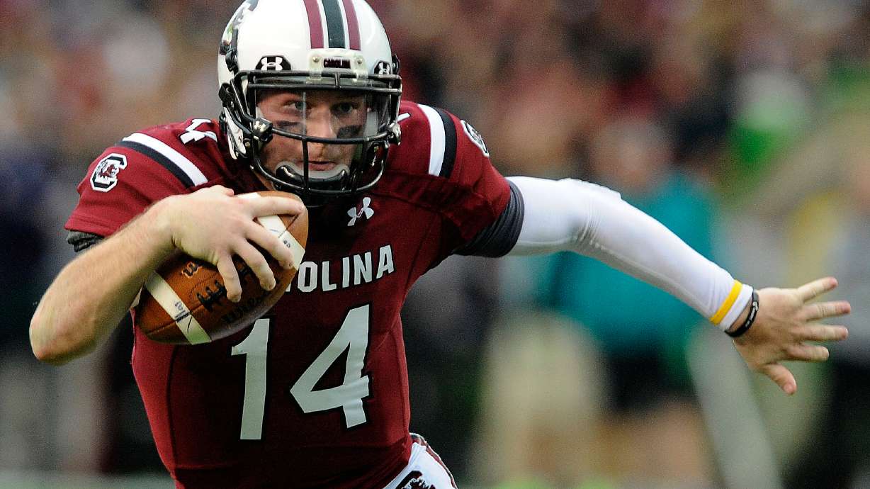 FILE - South Carolina quarterback Connor Shaw (14) runs for yardage during the first half of an NCAA college football game against Coastal Carolina, Nov. 23, 2013 in Columbia, S.C.