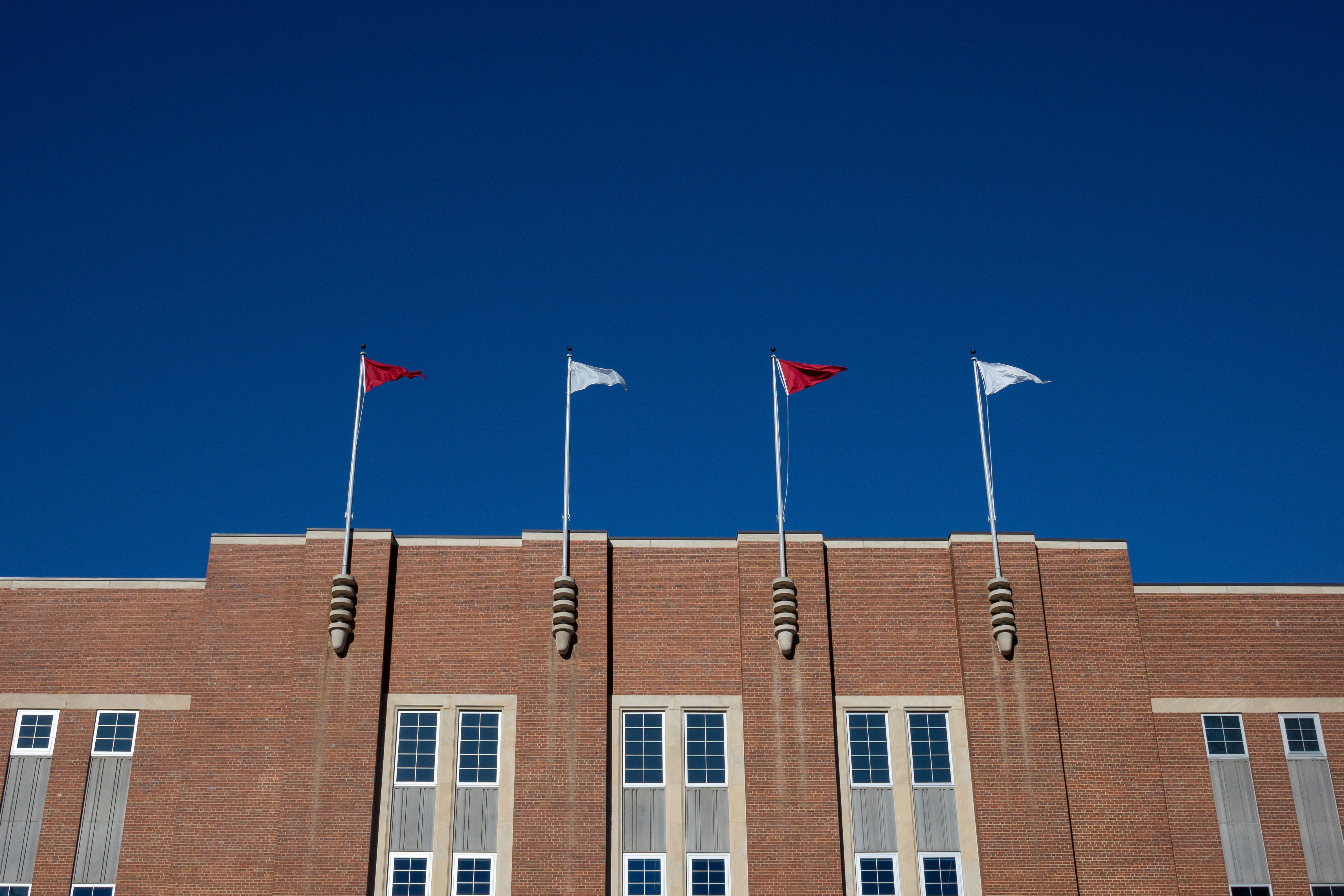 FILE - Flags fly at the Reynolds Coliseum at North Carolina State University Feb. 19, 2022, in Raleigh, N.C.