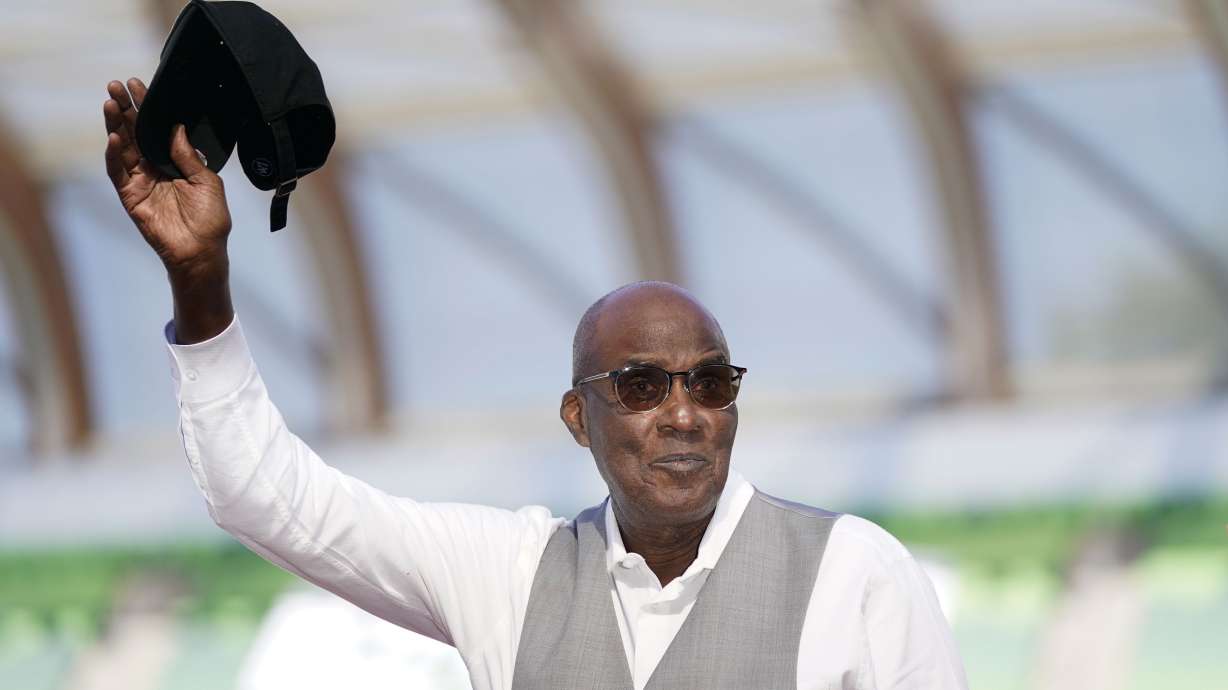 FILE - Bobby Kersee holds up his hat as he is honored as the 2023 USATF Legend Coach of the Year the during the U.S. track and field championships in Eugene, Ore., Saturday, July 8, 2023.