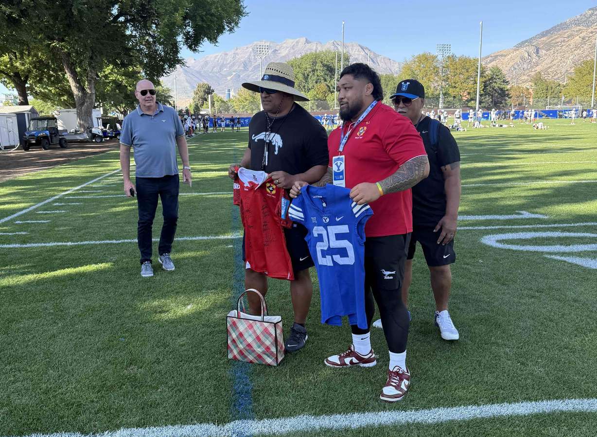 BYU head football coach Kalani Sitake, left, exchanges jerseys with Tongan international prop Ben Tameifuna during the 'Ikale Tahi's visit to Provo, Tuesday, Sept. 16, 2025.