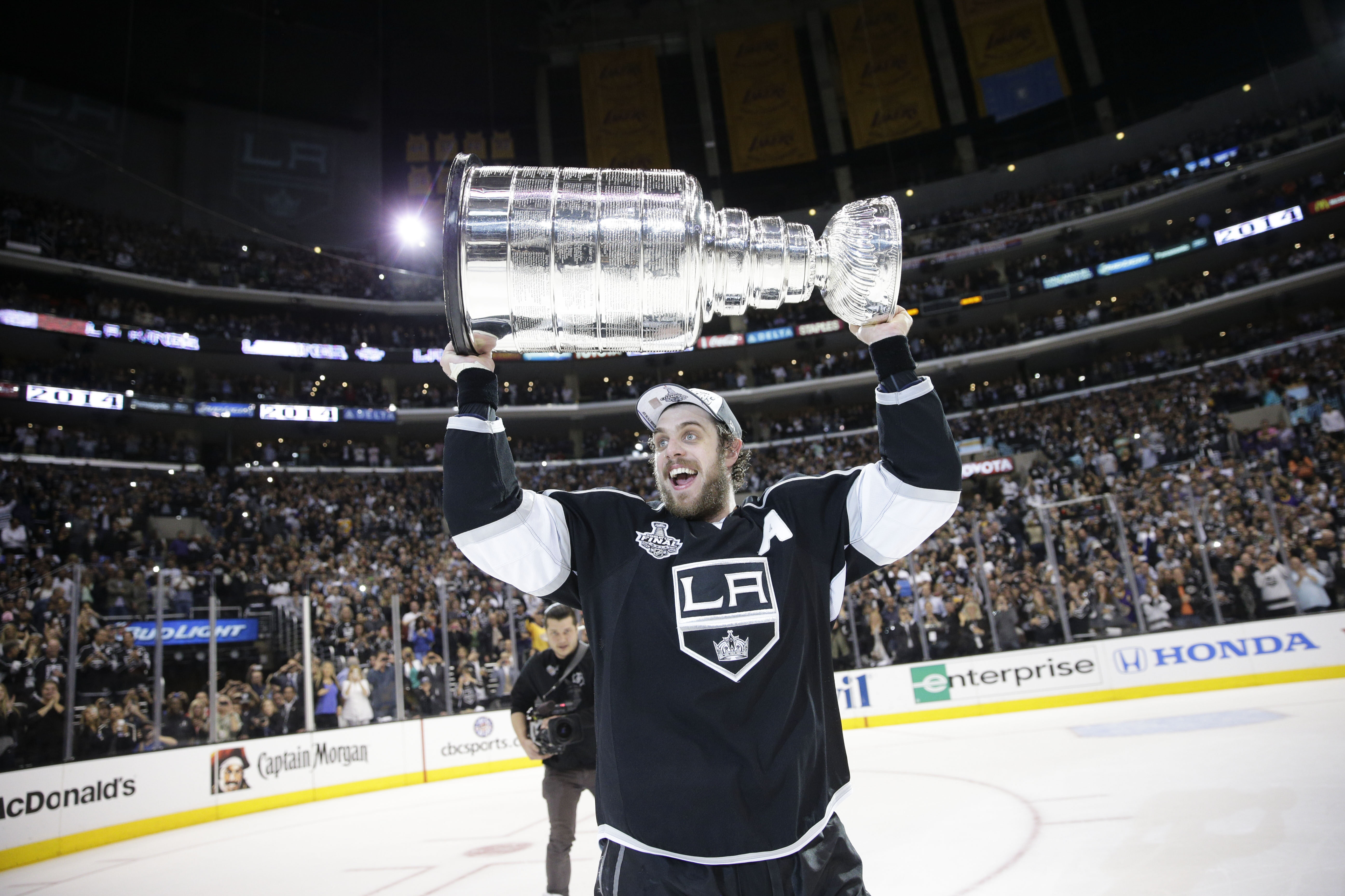 FILE - Los Angeles Kings center Anze Kopitar, of Slovenia, carries the Stanley Cup after beating the New York Rangers in double in Game 5 of the NHL Stanley Cup Final series, June 13, 2014, in Los Angeles.