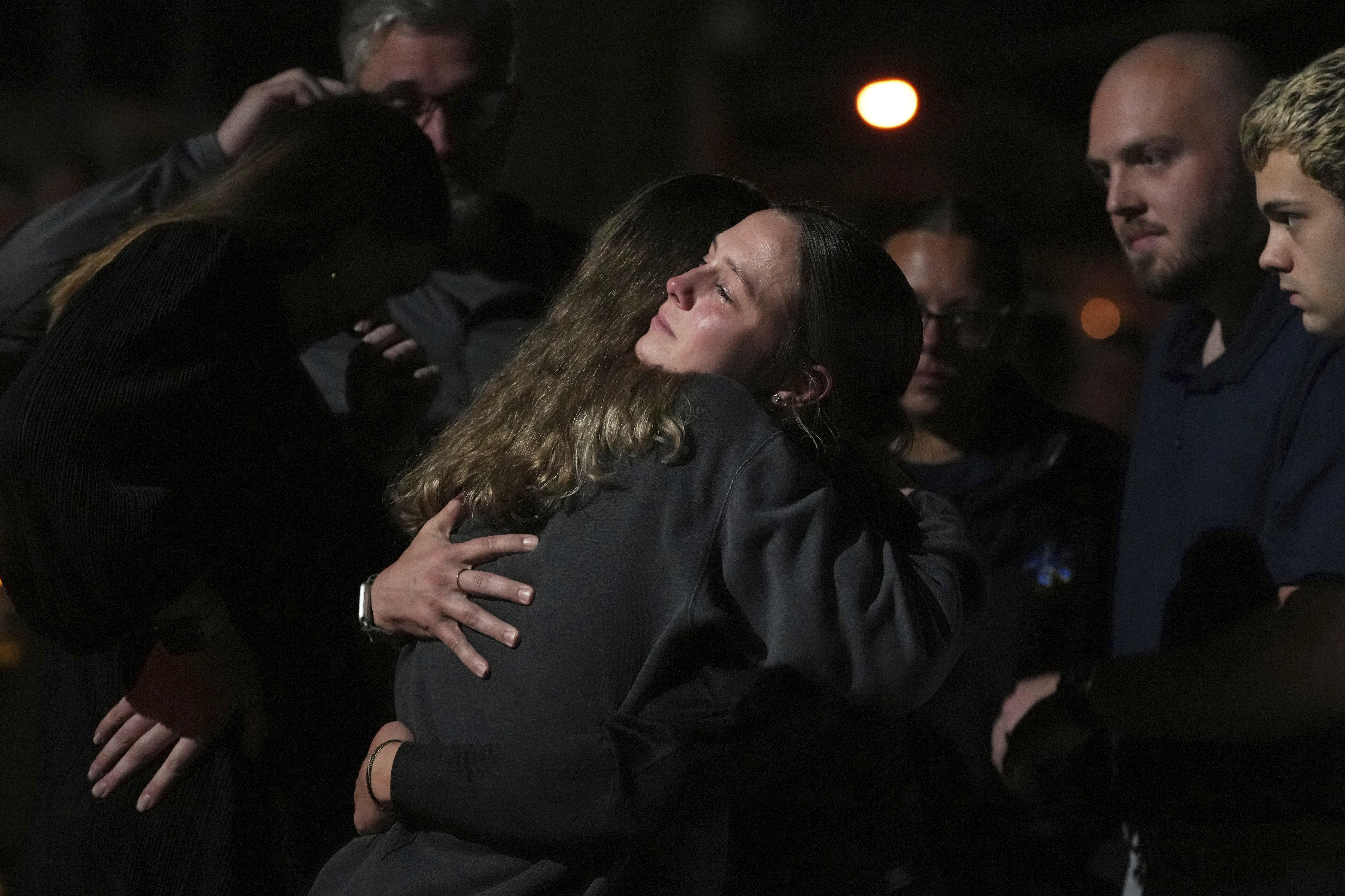 Attendees share a hug during a vigil at Spring Grove Alliance church Thursday, in Spring Grove, Pa. A suspected stalker armed with a rifle ambushed police officers who came to arrest him, killing three of them, authorities said.
