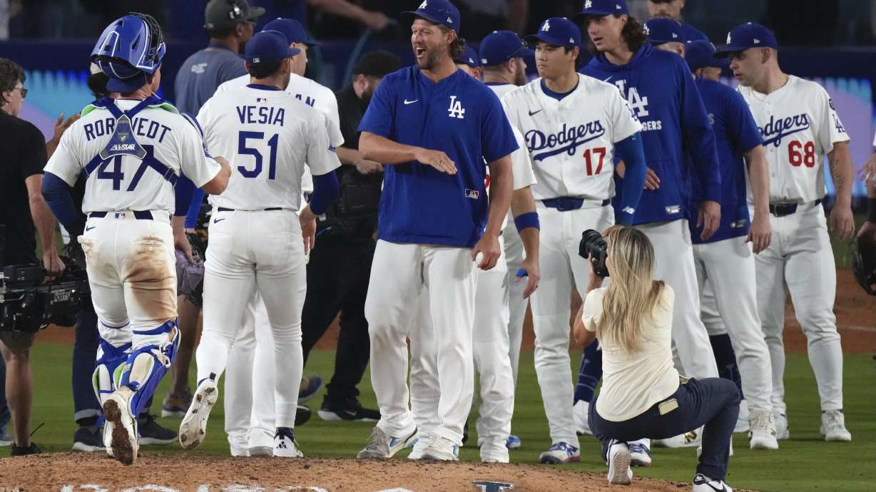 Los Angeles Dodgers' Clayton Kershaw, center, congratulates members of his team after the Dodgers defeated the San Francisco Giants in a baseball game Thursday, Sept. 18, 2025, in Los Angeles.