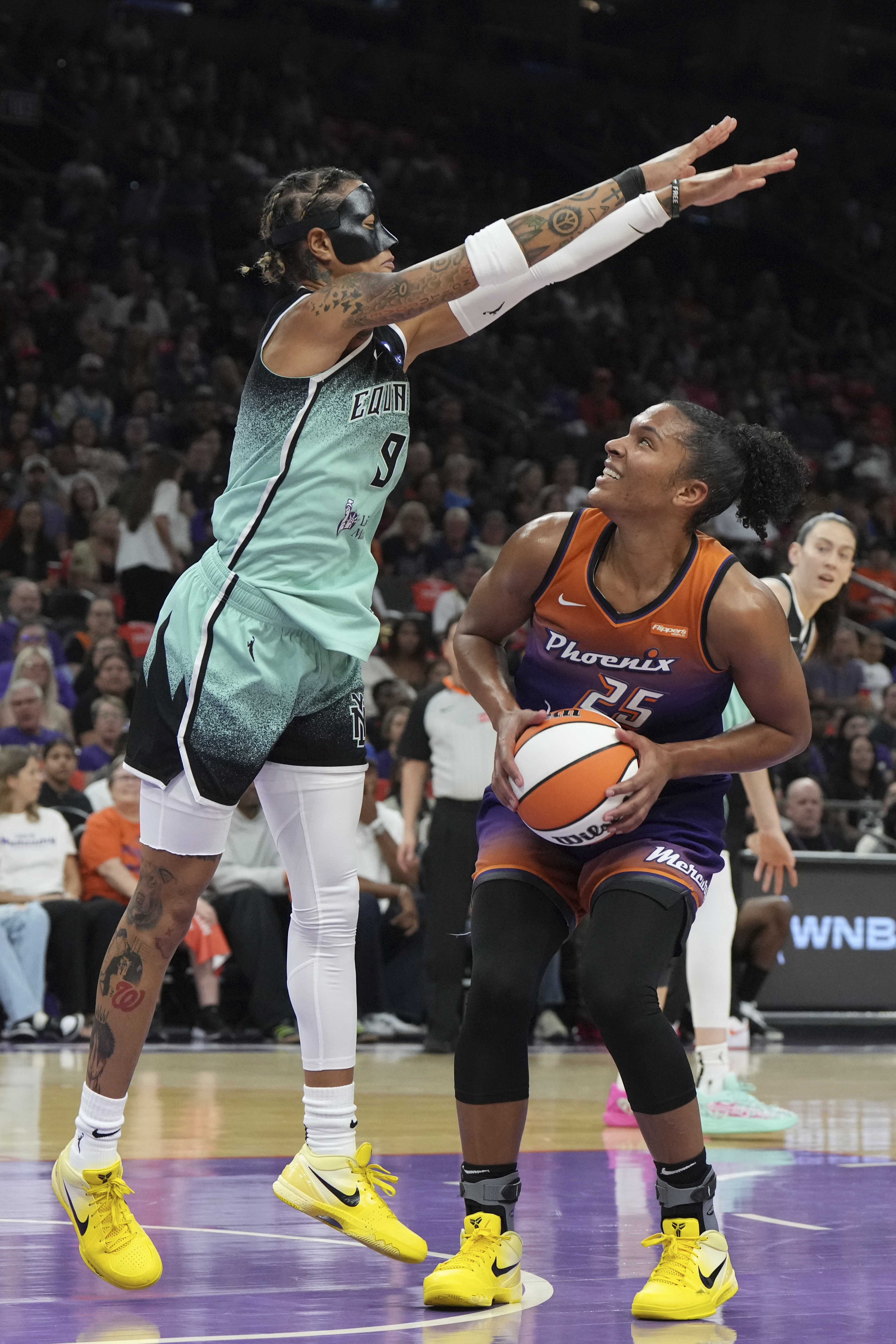New York Liberty guard Natasha Cloud (9) defends against a shot by Phoenix Mercury forward Alyssa Thomas (25) during the first half of Game 3 in the first round of the WNBA basketball playoffs, Friday, Sept. 19, 2025, in Phoenix. 