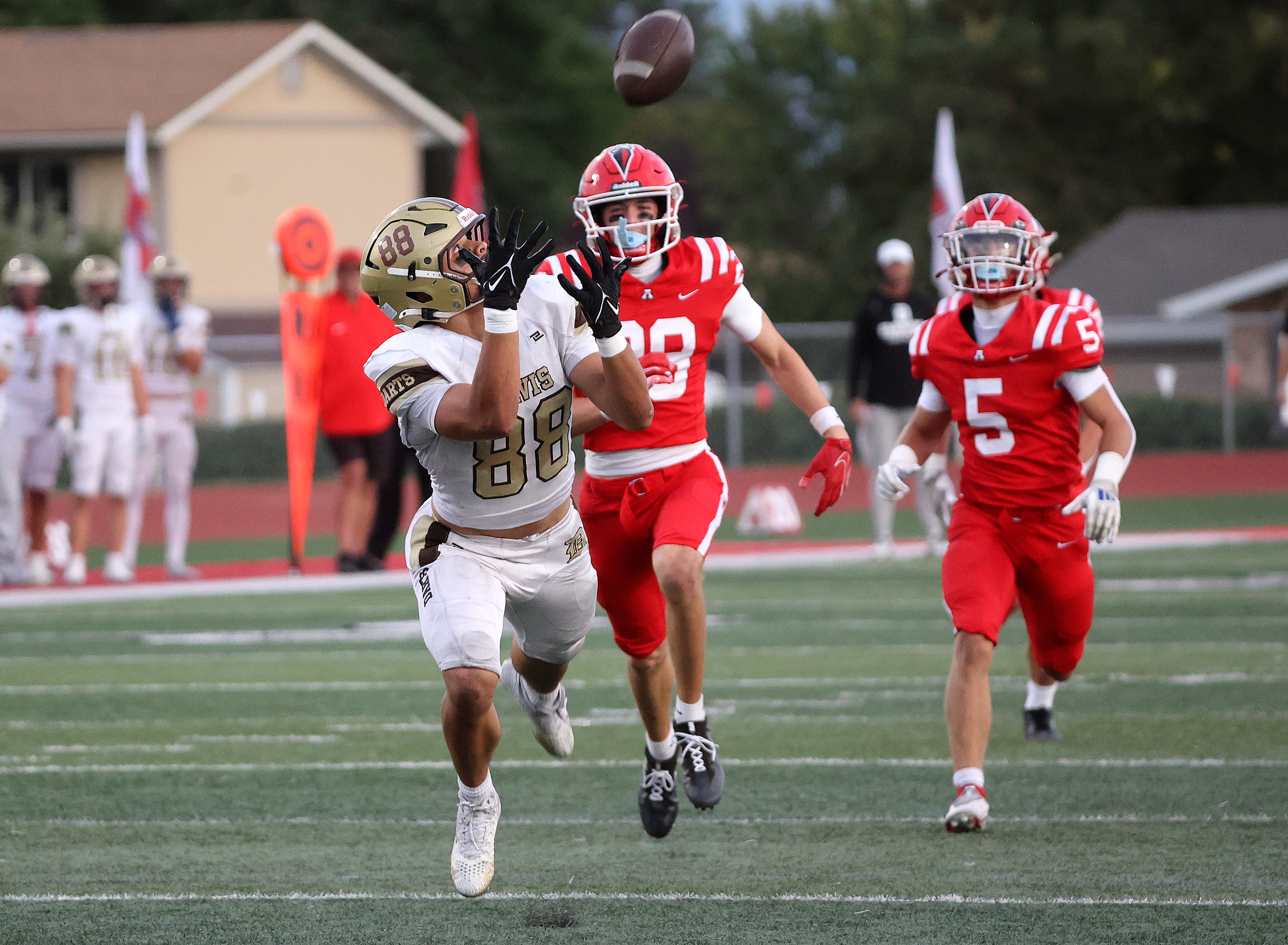 Davis High’s Jaxton Itaaehau completes a pass as American Fork’s Lincoln Miller and Noah Behm trail him during a varsity football game at American Fork High School in American Fork on Friday, Sept. 19, 2025. Davis won 29-15.