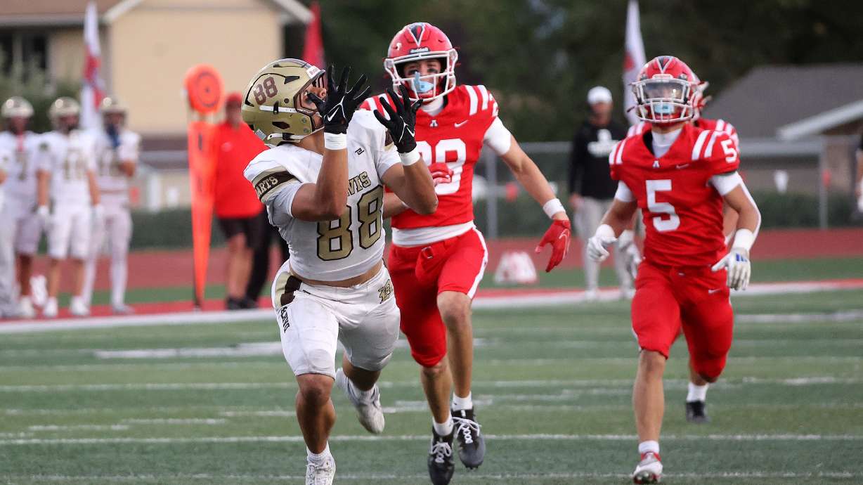Davis High’s Jaxton Itaaehau completes a pass as American Fork’s Lincoln Miller and Noah Behm trail him during a varsity football game at American Fork High School in American Fork on Friday, Sept. 19, 2025. Davis won 29-15.