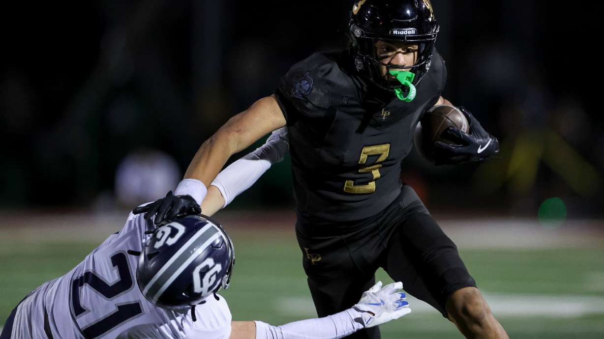 Lone Peak’s Kennan Pula (3) stiff-arms Corner Canyon’s Josh Harris (21) during the second half of a football game at Lone Peak High School in Highland on Friday, Sept. 19, 2025.