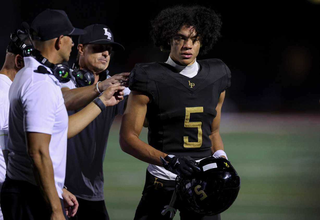 Lone Peak's Jaron Pula (5) speaks with his coaches as Lone Peak plays Corner Canyon in a football game at Lone Peak High School in Highland on Friday, Sept. 19, 2025.