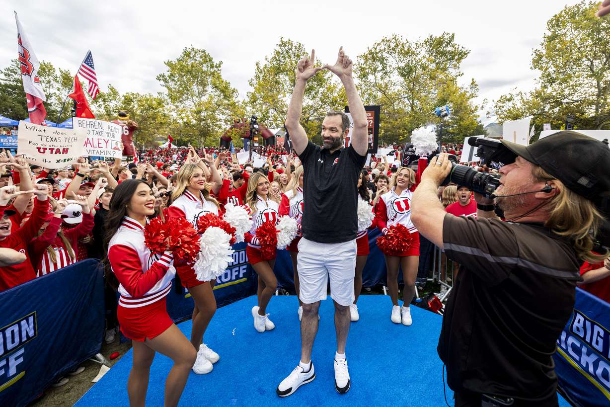 Utah men’s basketball head coach Alex Jensen flashes the “U” during Fox’s “Big Noon Kickoff” pregame show at the Smith’s Ultimate Tailgate Experience near Rice-Eccles Stadium in Salt Lake City on Saturday, Sept. 20, 2025, before the No. 16 Utah Utes played the No. 17 Texas Tech Red Raiders.