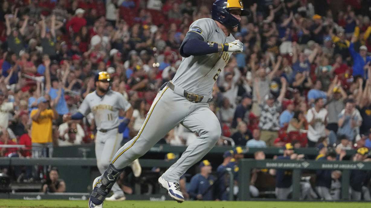 Milwaukee Brewers' Brice Turang, right, singles as Jackson Chourio, left, jogs in to score during the 10th inning of a baseball game against the St. Louis Cardinals Saturday, Sept. 20, 2025, in St. Louis.