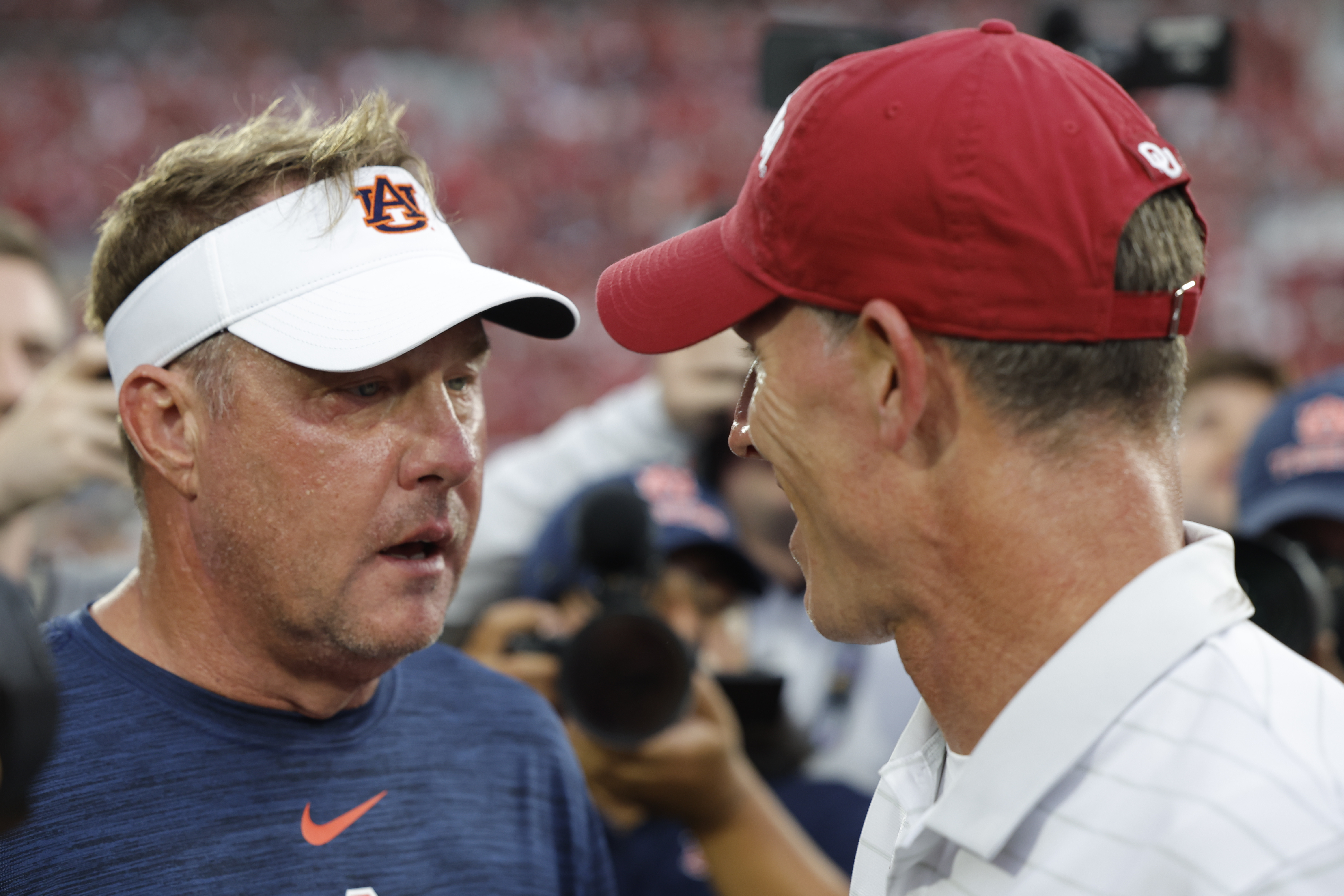Auburn head coach Hugh Freeze and Oklahoma head coach Brent Venables meet mid field after an NCAA college football game Saturday, Sept. 20, 2025, in Norman, Okla. 