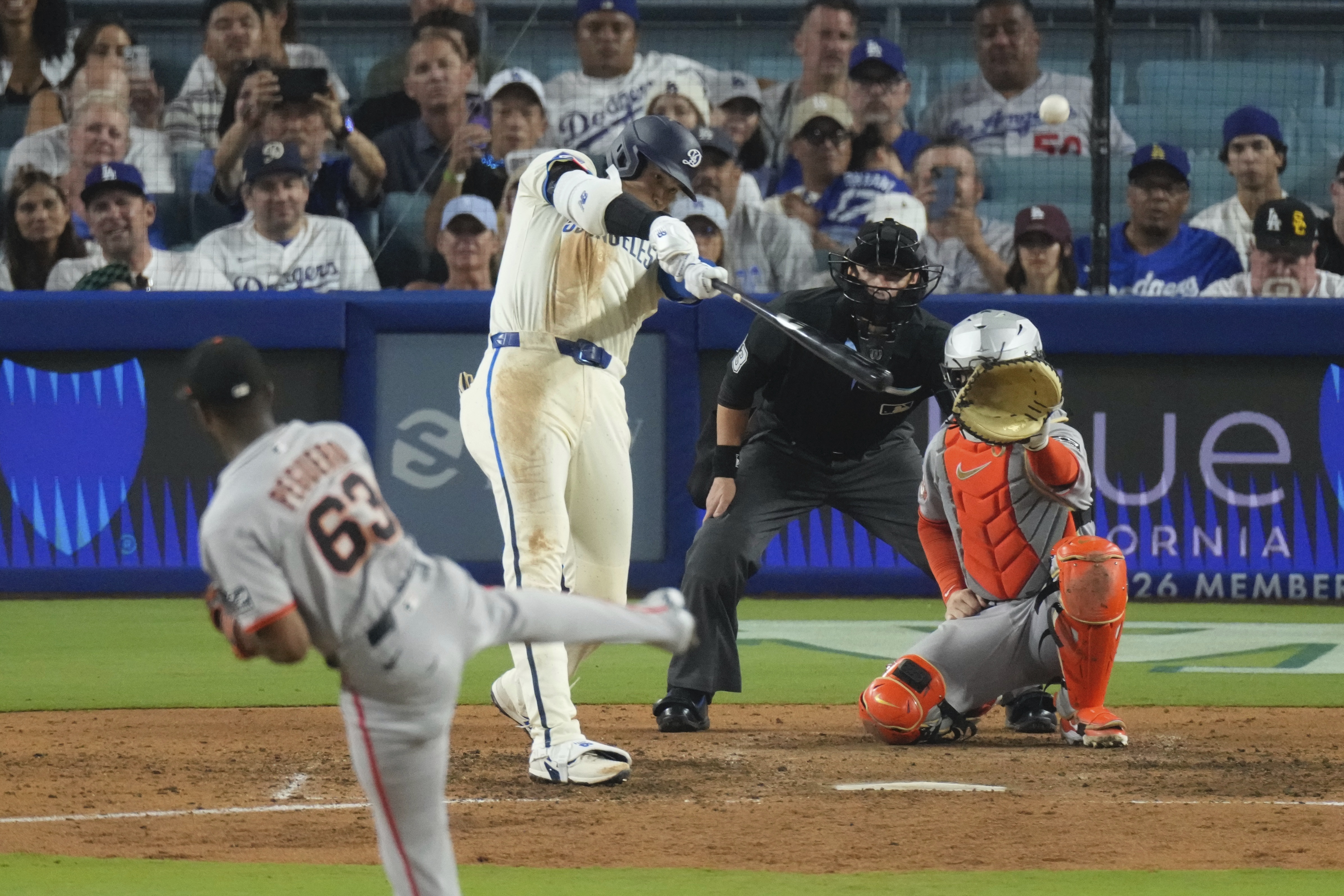 Los Angeles Dodgers' Shohei Ohtani, second from left, heads hits a solo home run as San Francisco Giants relief pitcher Joel Peguero, left, and catcher Patrick Bailey watch during the sixth inning of a baseball game, Saturday, Sept. 20, 2025, in Los Angeles. 
