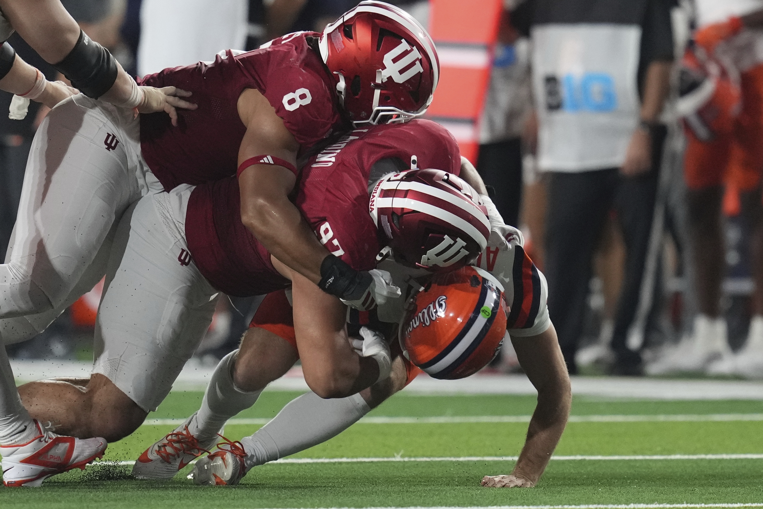 Illinois quarterback Luke Altmyer (9) is sacked by Indiana defensive lineman Stephen Daley (8)and defensive lineman Mario Landino (97) during the first half of an NCAA college football game, Saturday, Sept. 20, 2025, in Bloomington, Ind. 