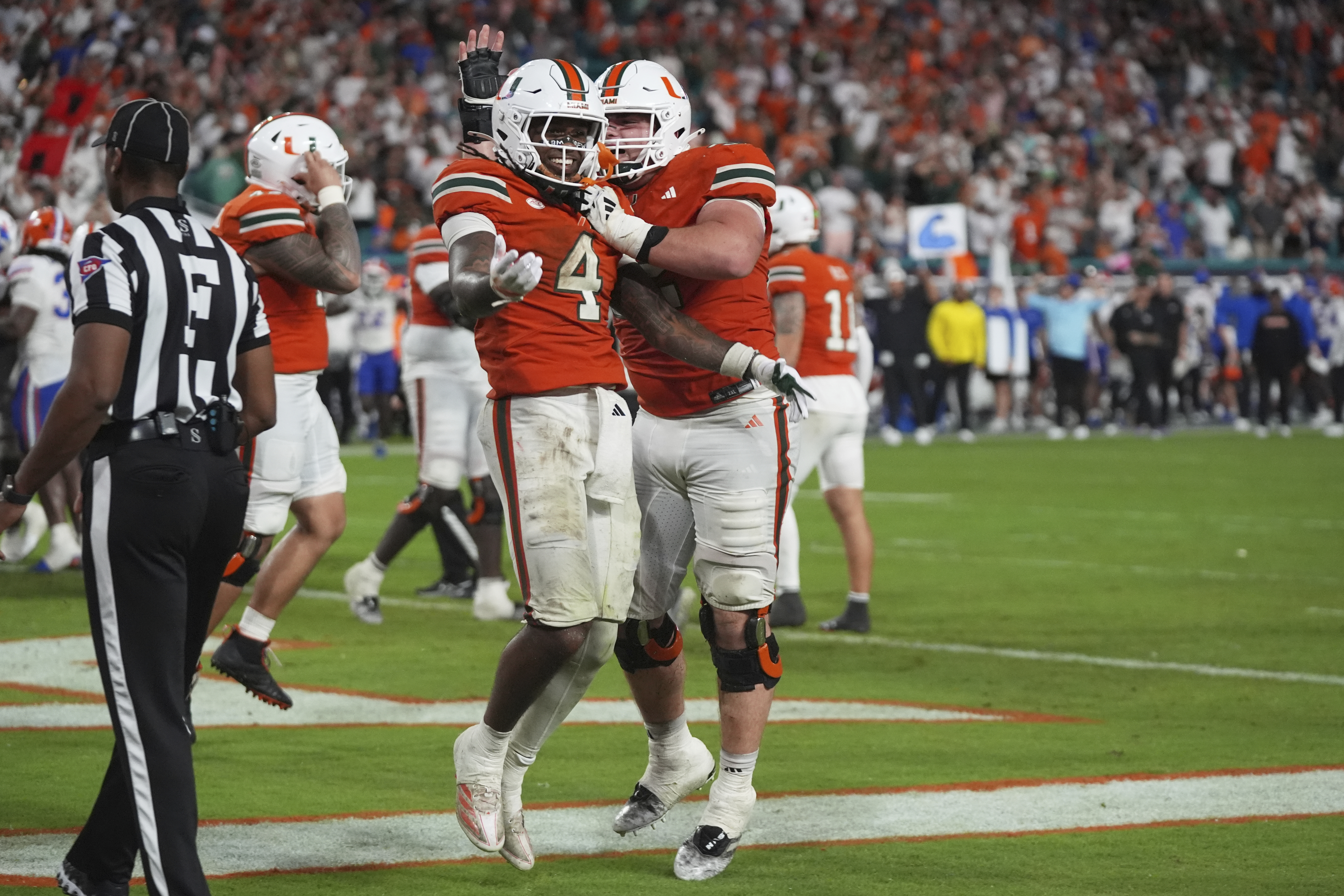 Miami running back Mark Fletcher Jr. (4) celebrates with offensive lineman James Brockermeyer, right, after scoring a touchdown during the second half of an NCAA college football game against Florida, Saturday, Sept. 20, 2025, in Miami Gardens, Fla. 