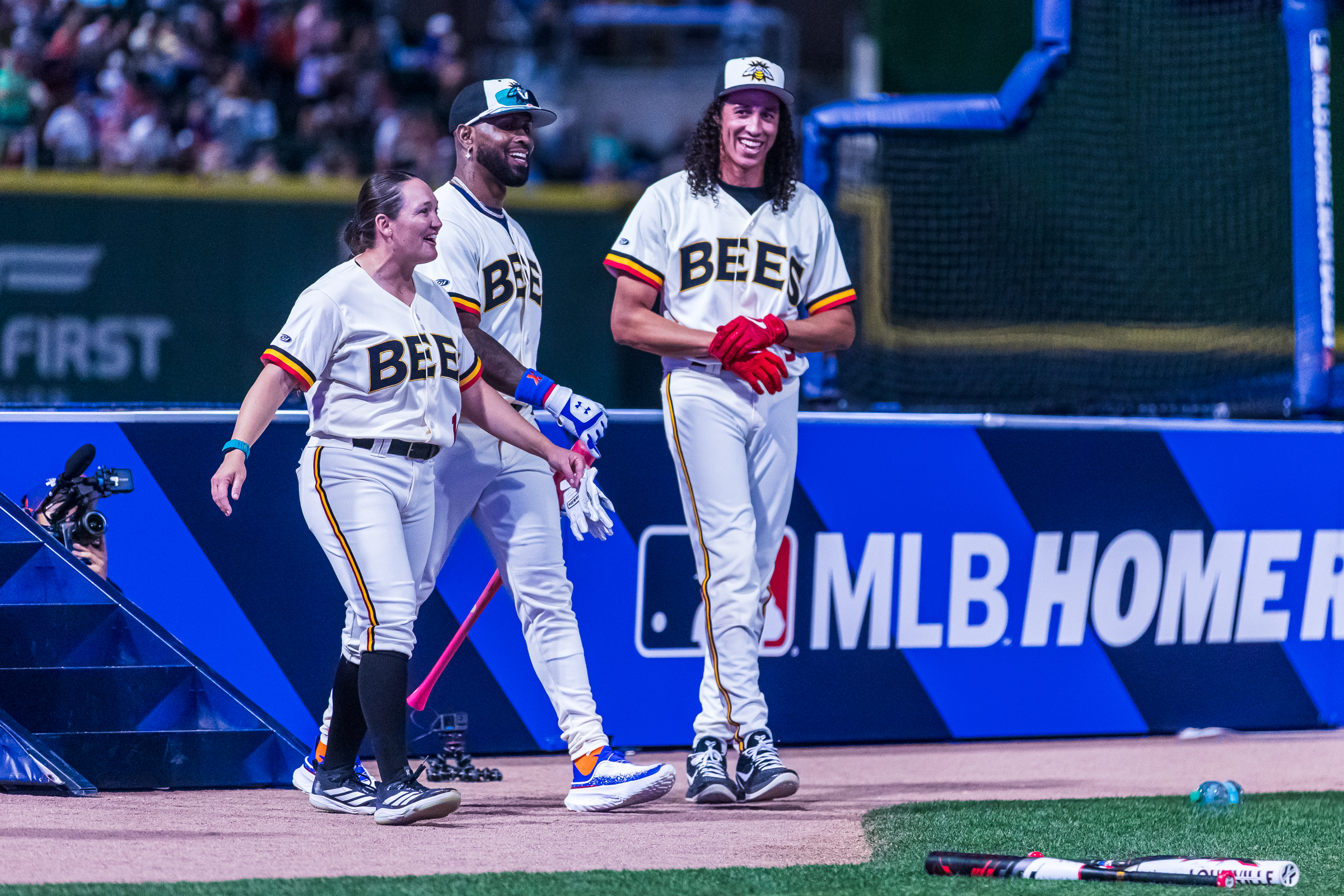 Hannah Flippen, left, Jose Reyes, center, and Cole Tucker, right, celebrate after a successful batting round during the quarterfinals of Home Run Derby X at America First Square in South Jordan on Friday.