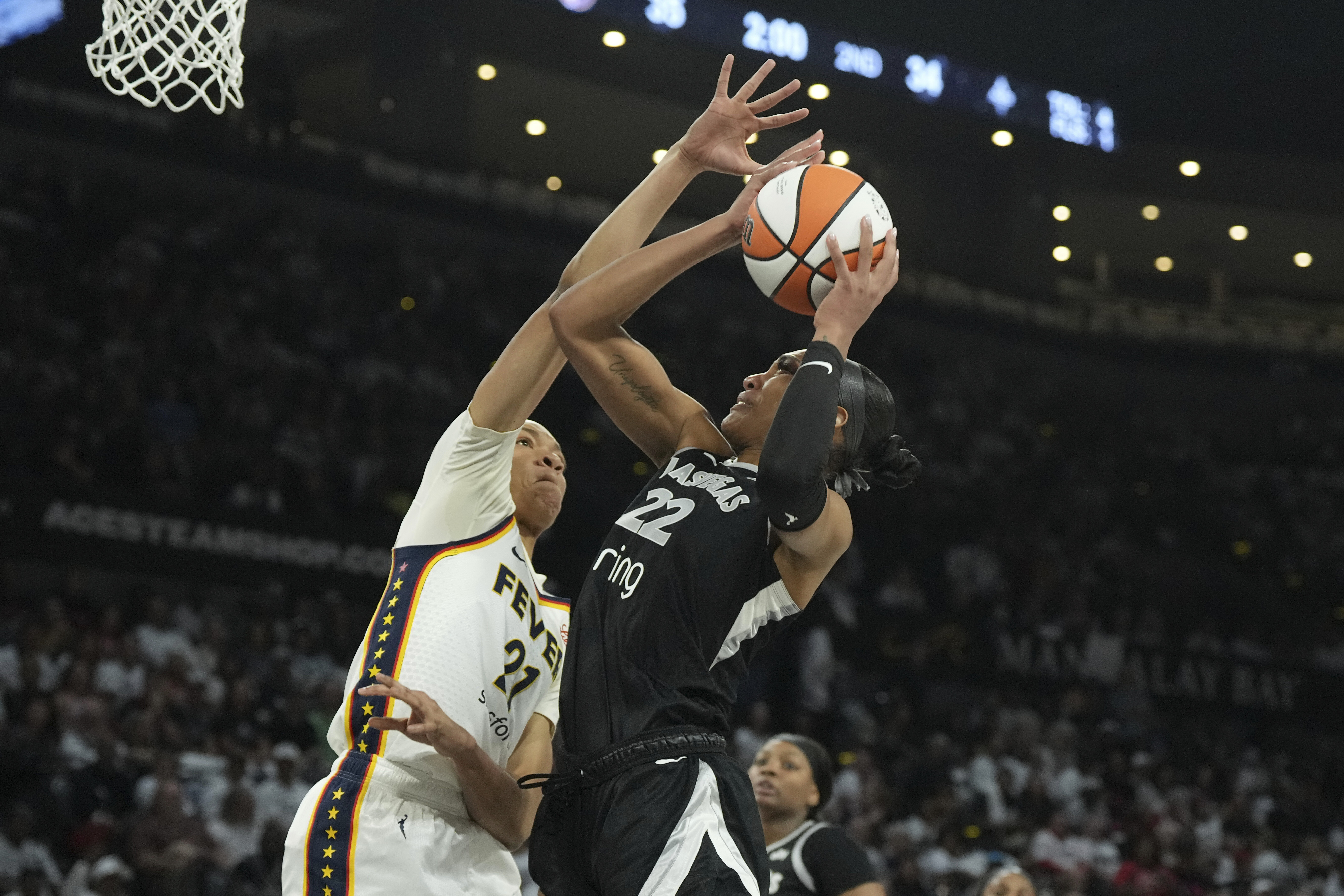 Las Vegas Aces center A'ja Wilson (22) looks to shoot against Indiana Fever forward Makayla Timpson, left, in the first half of Game 1 of a WNBA basketball playoff semifinals series Sunday, Sept. 21, 2025, in Las Vegas. 
