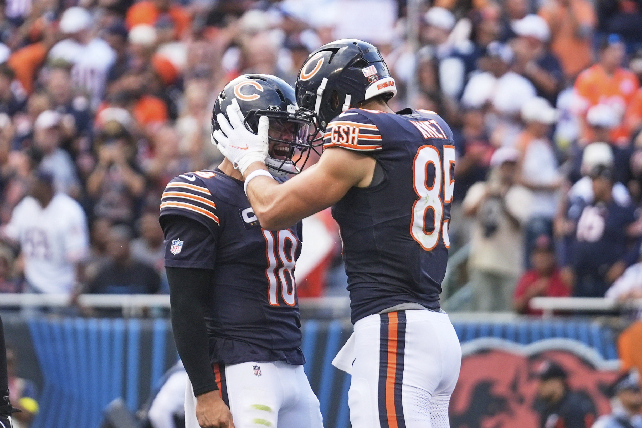 Chicago Bears' Caleb Williams (18) and Cole Kmet (85) celebrate after Kmet caught a touchdown pass in the first half of an NFL football game against the Dallas Cowboys Sunday, Sept. 21, 2025, in Chicago. 