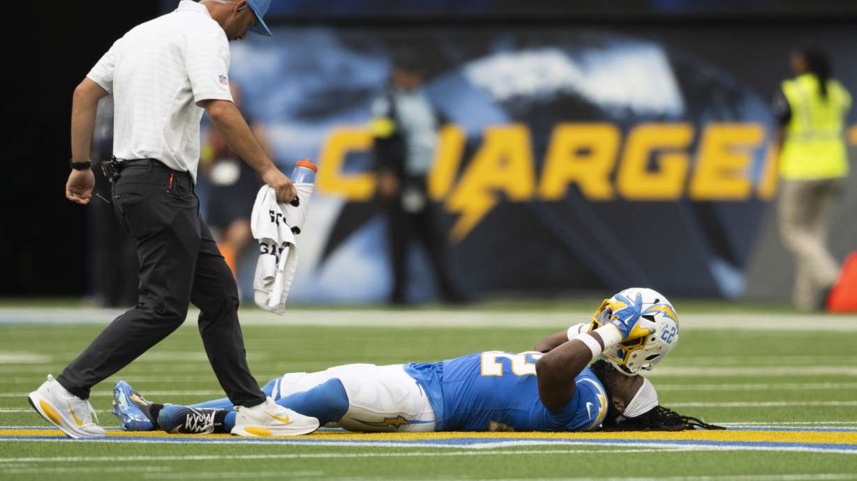 Los Angeles Chargers running back Najee Harris, right, lays on the ground after getting injured during an NFL football game against the Denver Broncos, Sunday, Sept. 21, 2025, in Inglewood, Calif.