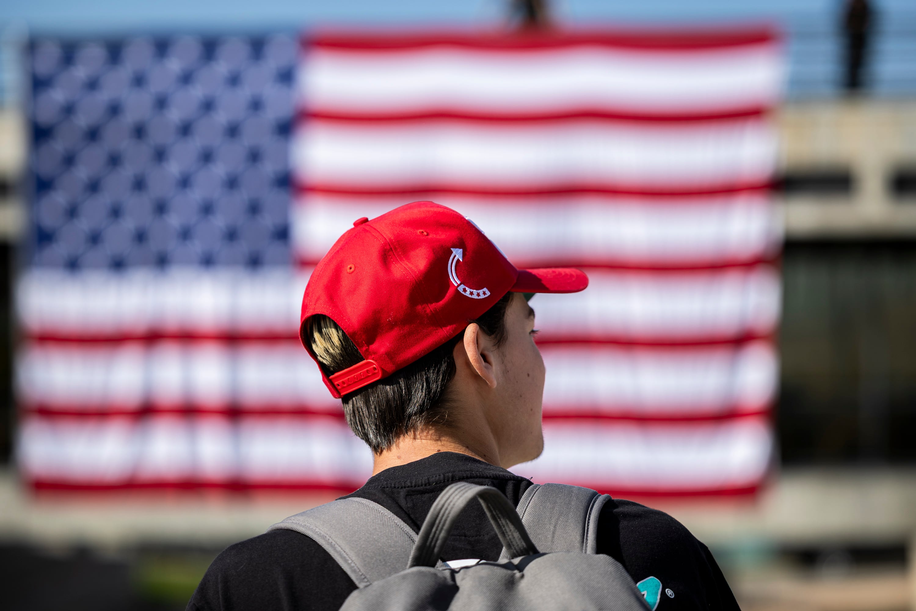 Ryker White, a freshman at Utah Valley University, wears a hat with the Turning Point USA logo on it as he talks with a friend near an American flag displayed in the courtyard on the campus of UVU in Orem on Wednesday. 