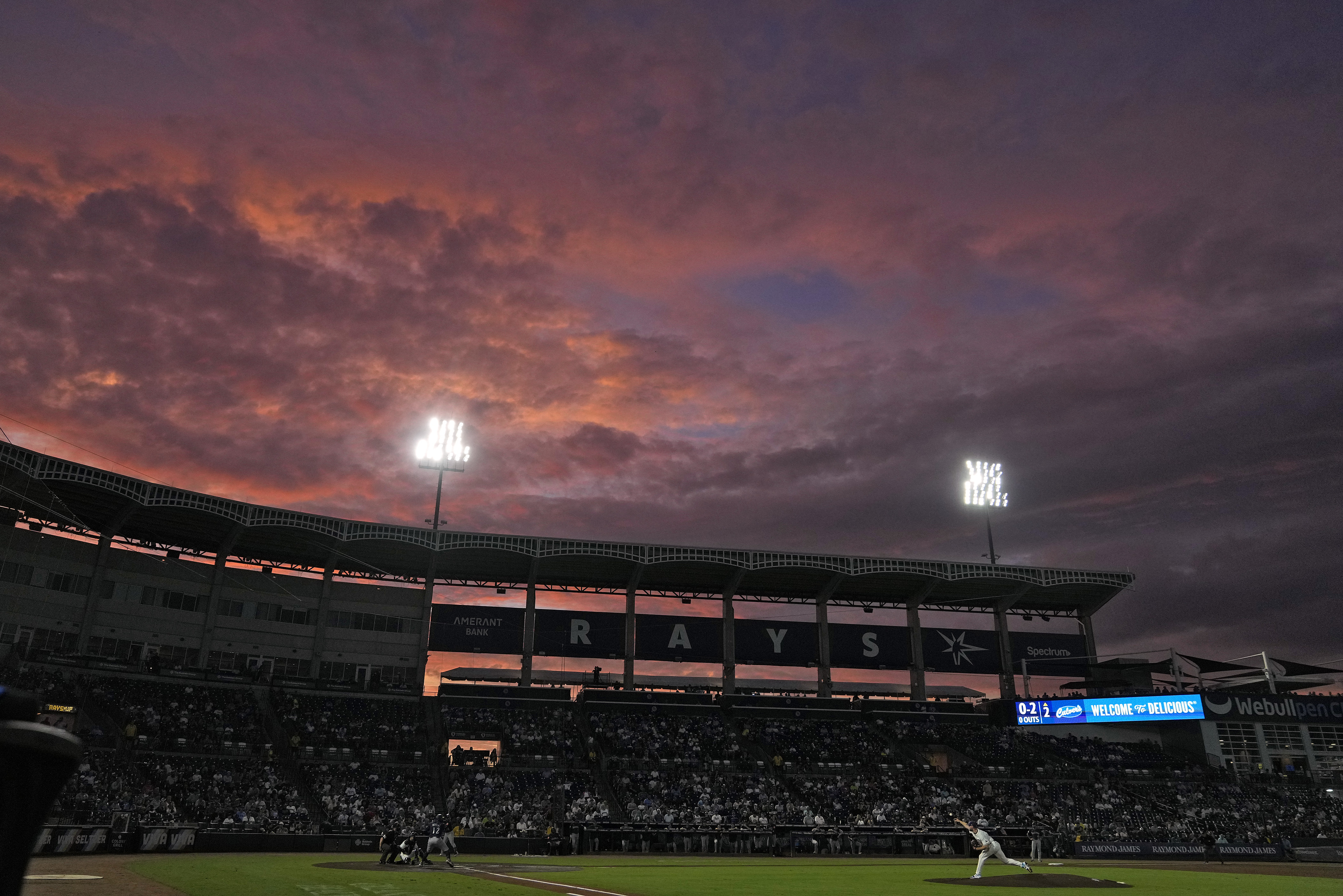 The sun sets over Steinbrenner Field during the second inning of a baseball game between the Tampa Bay Rays and the Seattle Mariners Wednesday, Sept. 3, 2025, in Tampa, Fla.