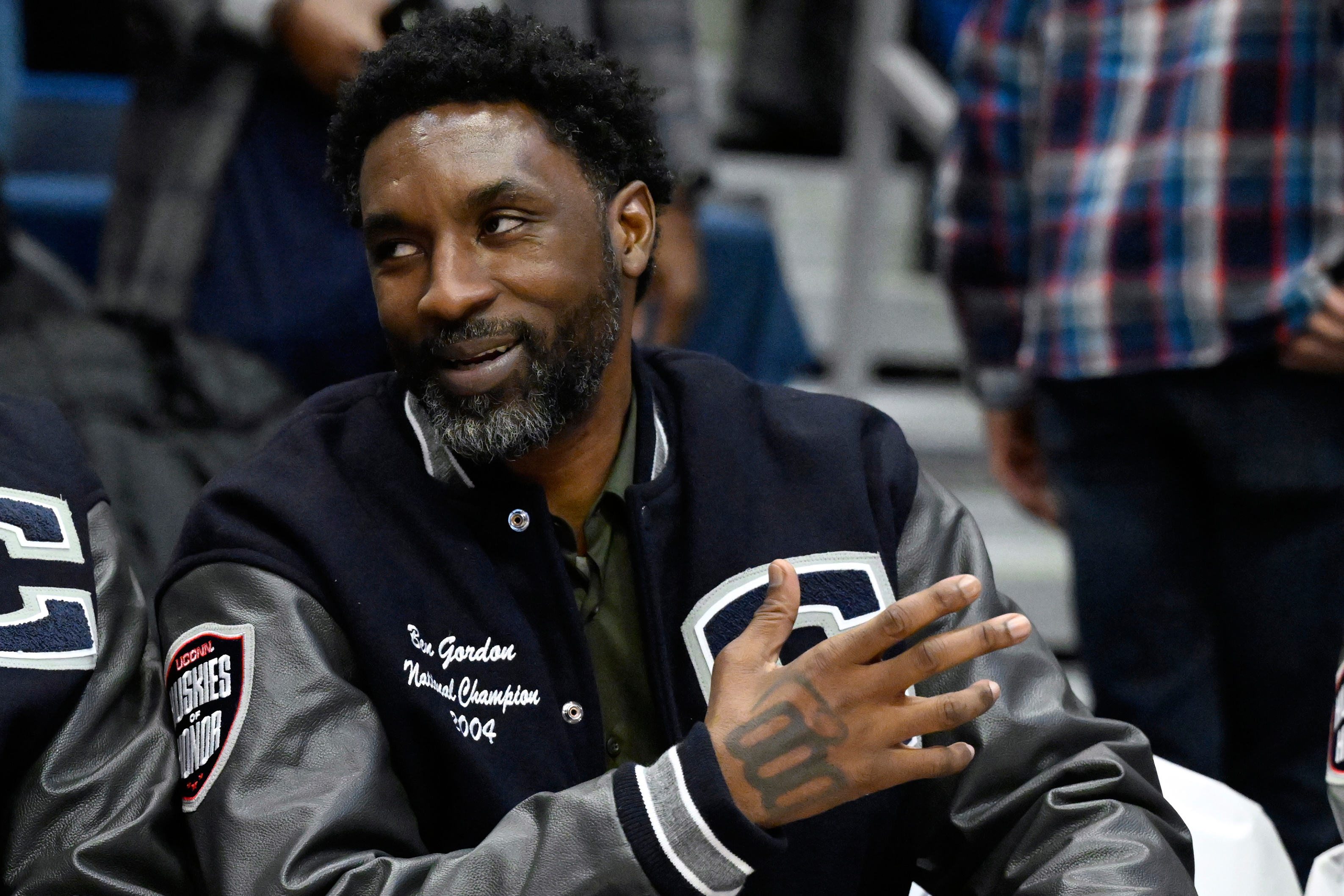 FILE- Former UConn and NBA player Ben Gordon sits on the sideline during a ceremony honoring the 2004 UConn men's championship basketball team during halftime of an NCAA college basketball game against Xavier, Jan. 28, 2024, in Hartford, Conn. 