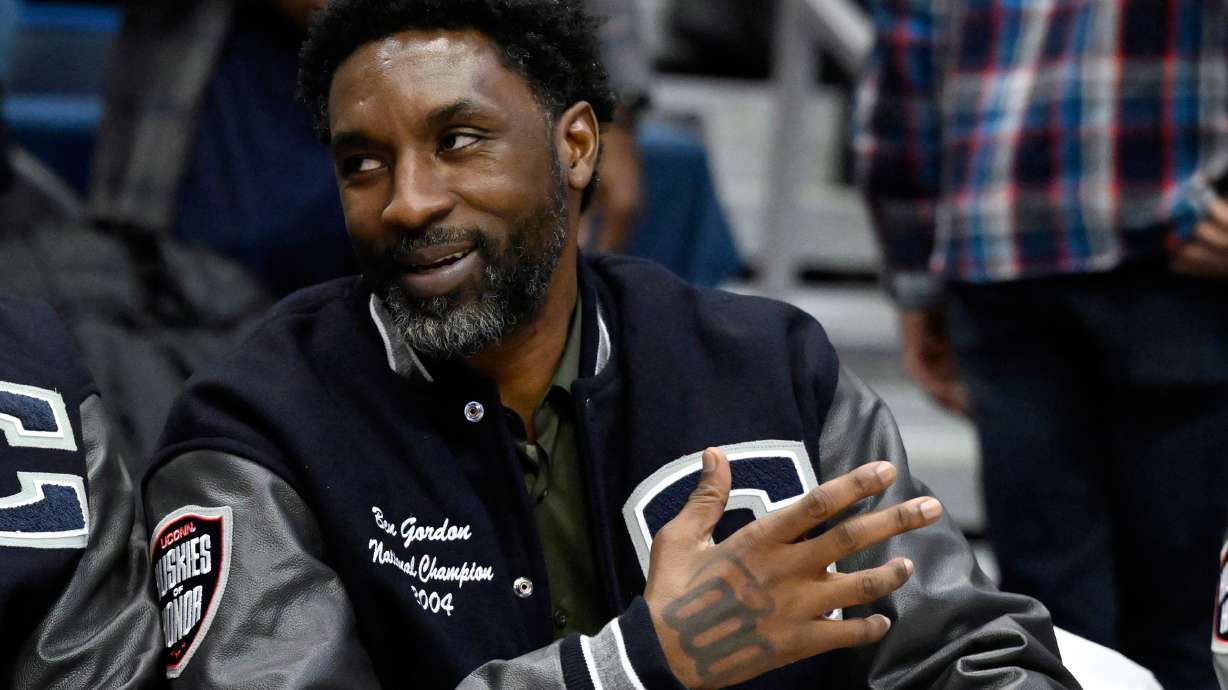 FILE- Former UConn and NBA player Ben Gordon sits on the sideline during a ceremony honoring the 2004 UConn men's championship basketball team during halftime of an NCAA college basketball game against Xavier, Jan. 28, 2024, in Hartford, Conn.