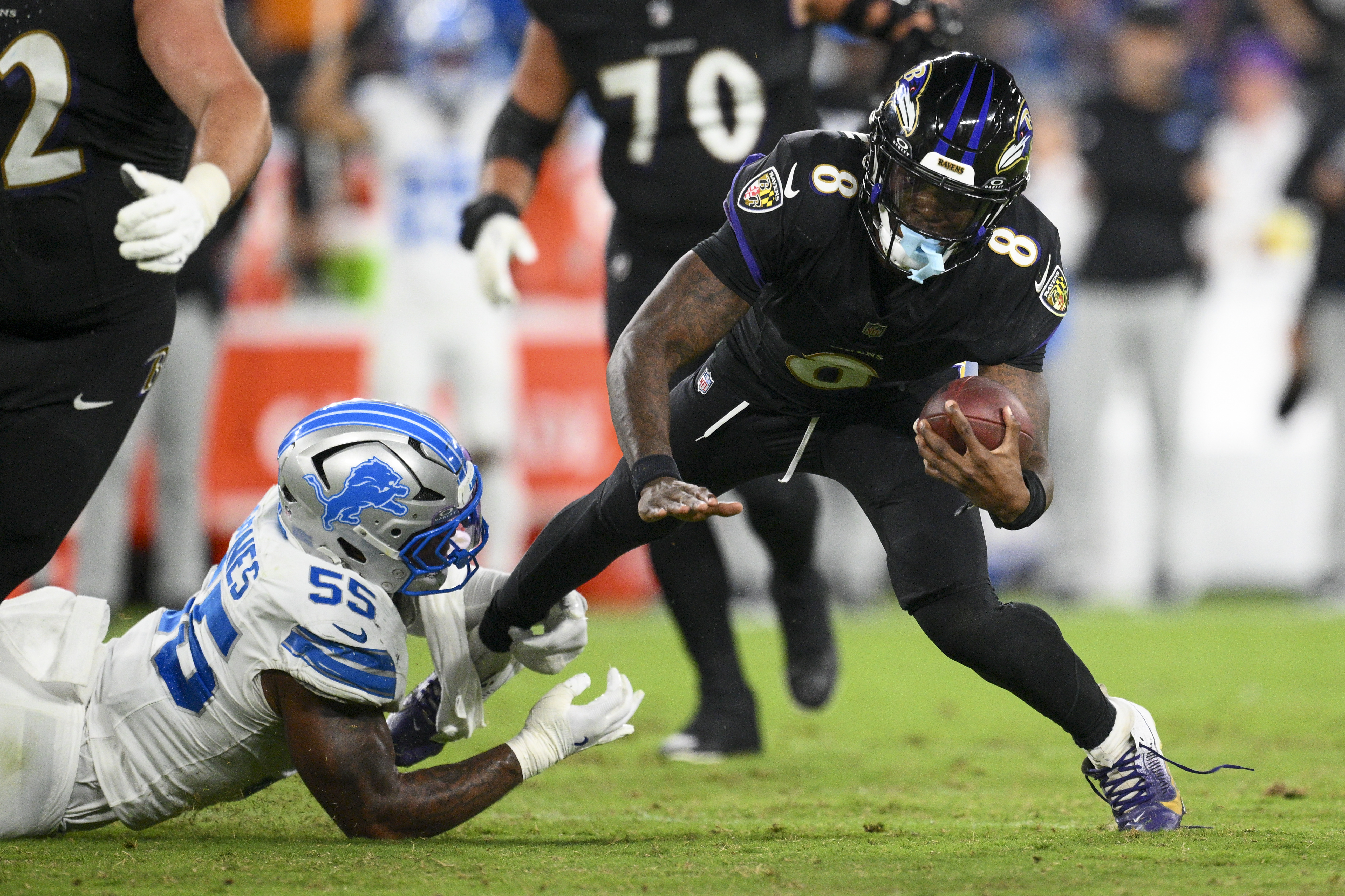 Baltimore Ravens quarterback Lamar Jackson (8) is tripped up by Detroit Lions linebacker Derrick Barnes (55) during the second half of an NFL football game Monday, Sept. 22, 2025, in Baltimore. 