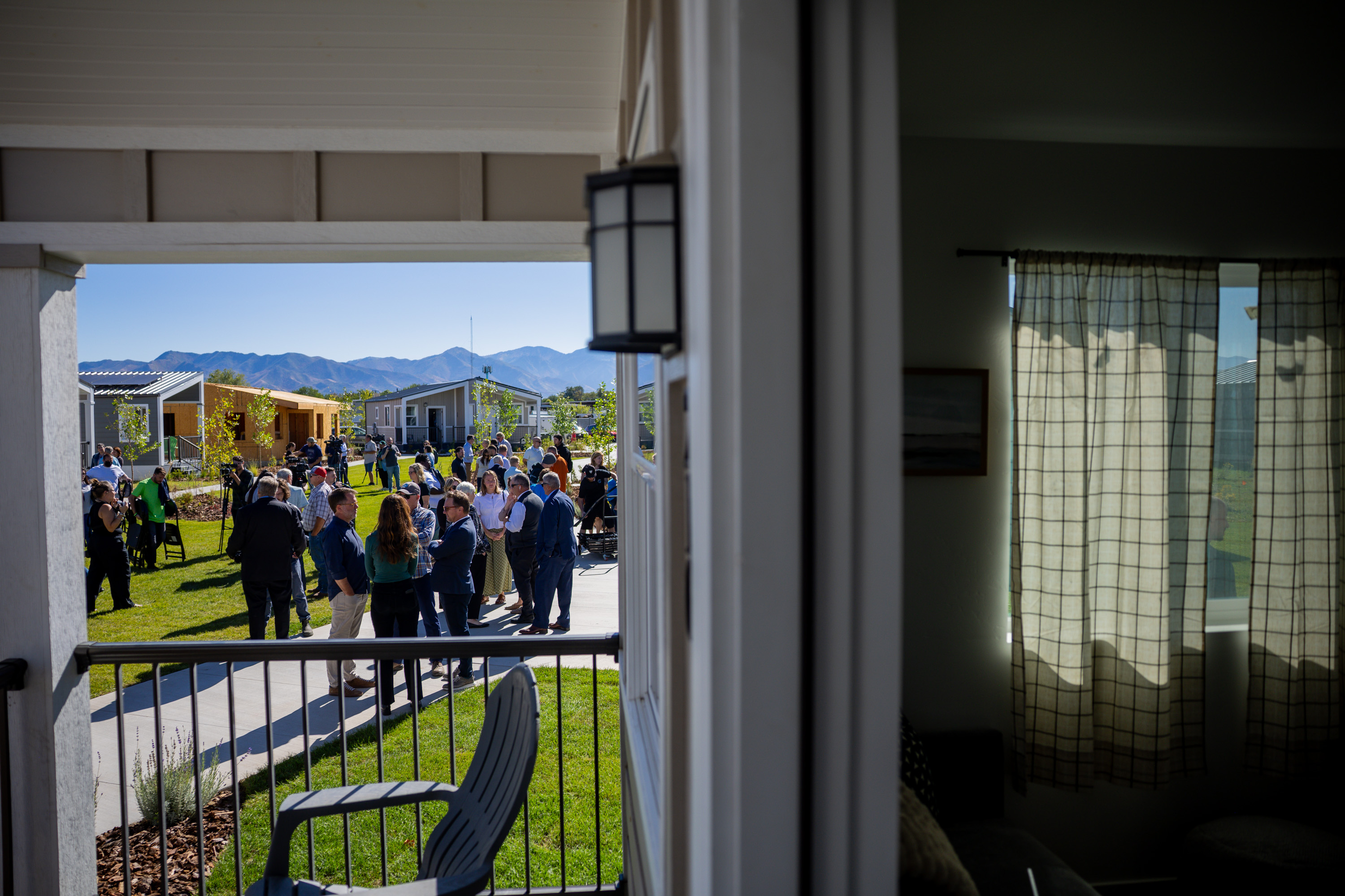 People mingle after a press conference celebrating the Other Side Village Phase 2 expansion after securing $30 million in donations to overcome chronic homelessness in the state at the Other Side Village in Salt Lake City on Tuesday.
