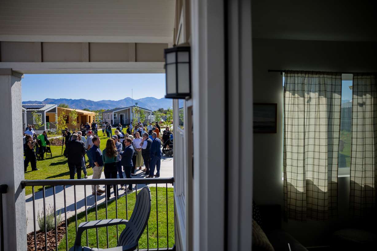 People mingle after a press conference celebrating the Other Side Village Phase 2 expansion after securing $30 million in donations to overcome chronic homelessness in the state at the Other Side Village in Salt Lake City on Tuesday.