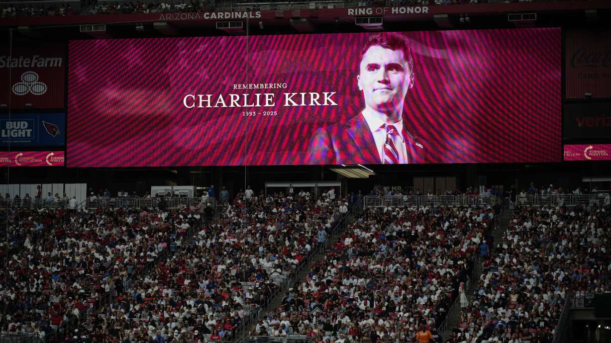 A photo of Charlie Kirk on a large screen at a memorial for Kirk on Sunday at State Farm Stadium in Glendale, Ariz.