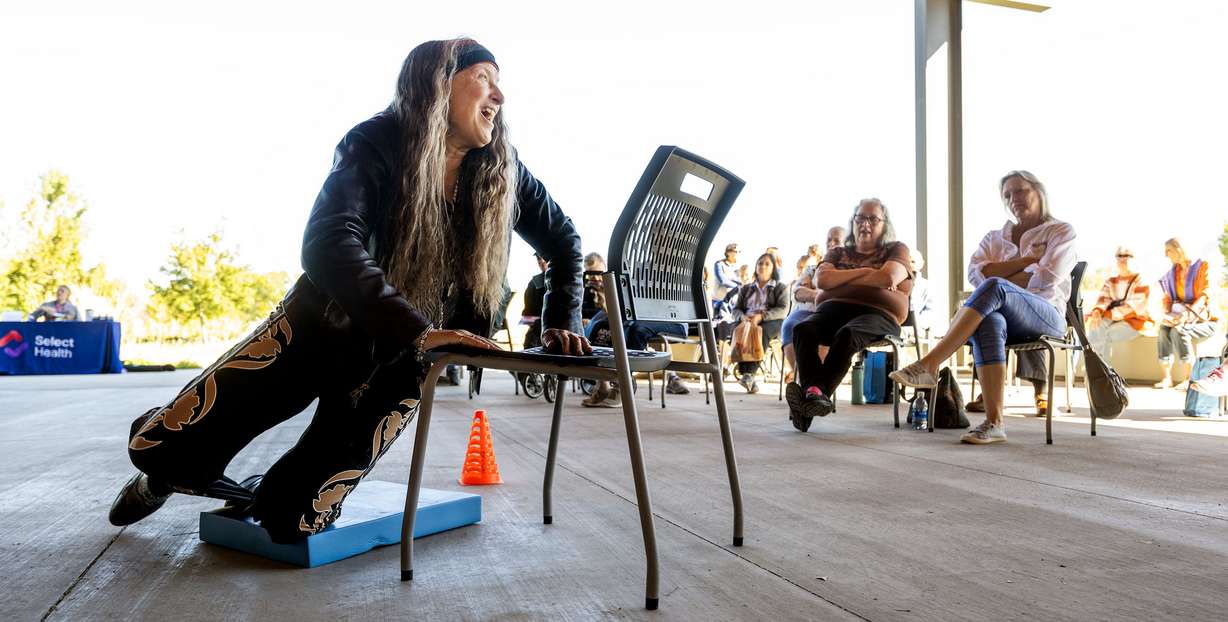 Janene Holberg, a physical therapist with Intermountain Health, shows different ways to get up after a fall as Salt Lake County hosts a free community event highlighting ways to prevent falls, at the Wheeler Farm Outdoor Education Center in Murray on Tuesday.