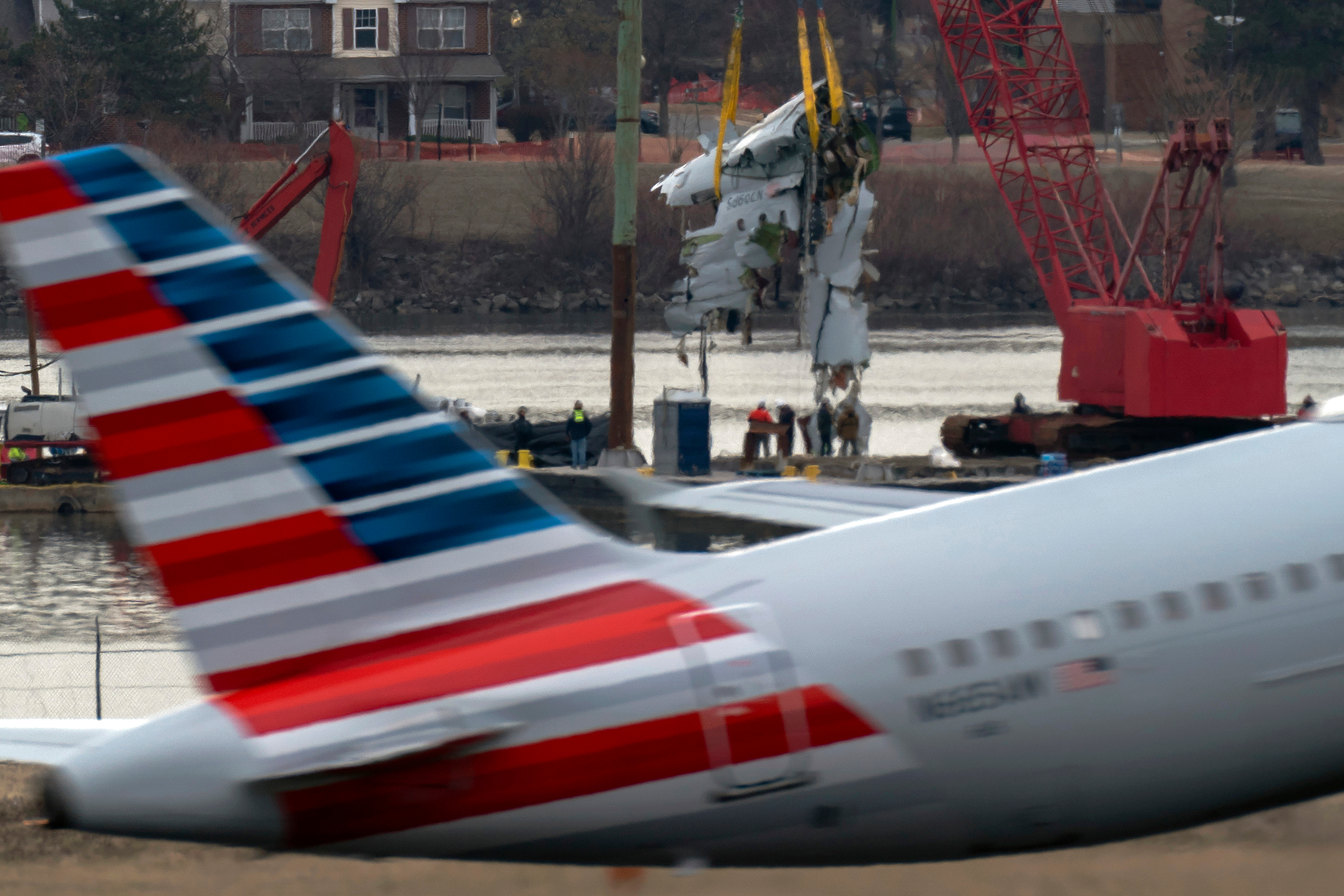 Crews pull up a part of a plane from the Potomac River near Ronald Reagan Washington National Airport, Feb. 3.