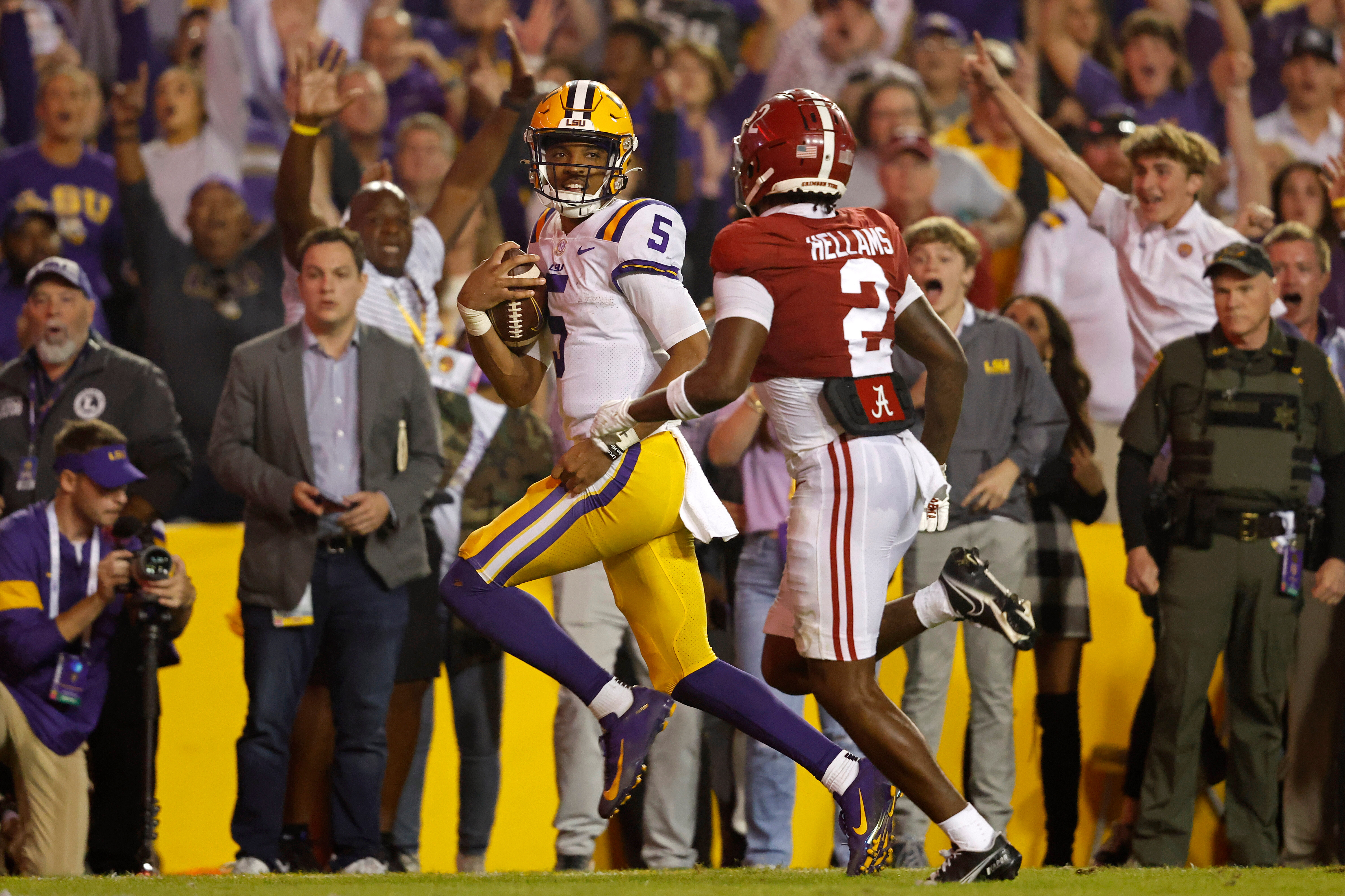 FILE - LSU quarterback Jayden Daniels (5) runs the ball past Alabama defensive back DeMarcco Hellams (2) to score a two-point conversion during overtime of an NCAA college football game in Baton Rouge, La., Nov. 5, 2022. 
