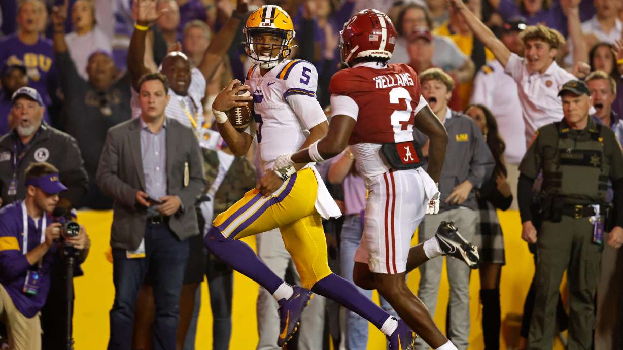 FILE - LSU quarterback Jayden Daniels (5) runs the ball past Alabama defensive back DeMarcco Hellams (2) to score a two-point conversion during overtime of an NCAA college football game in Baton Rouge, La., Nov. 5, 2022.