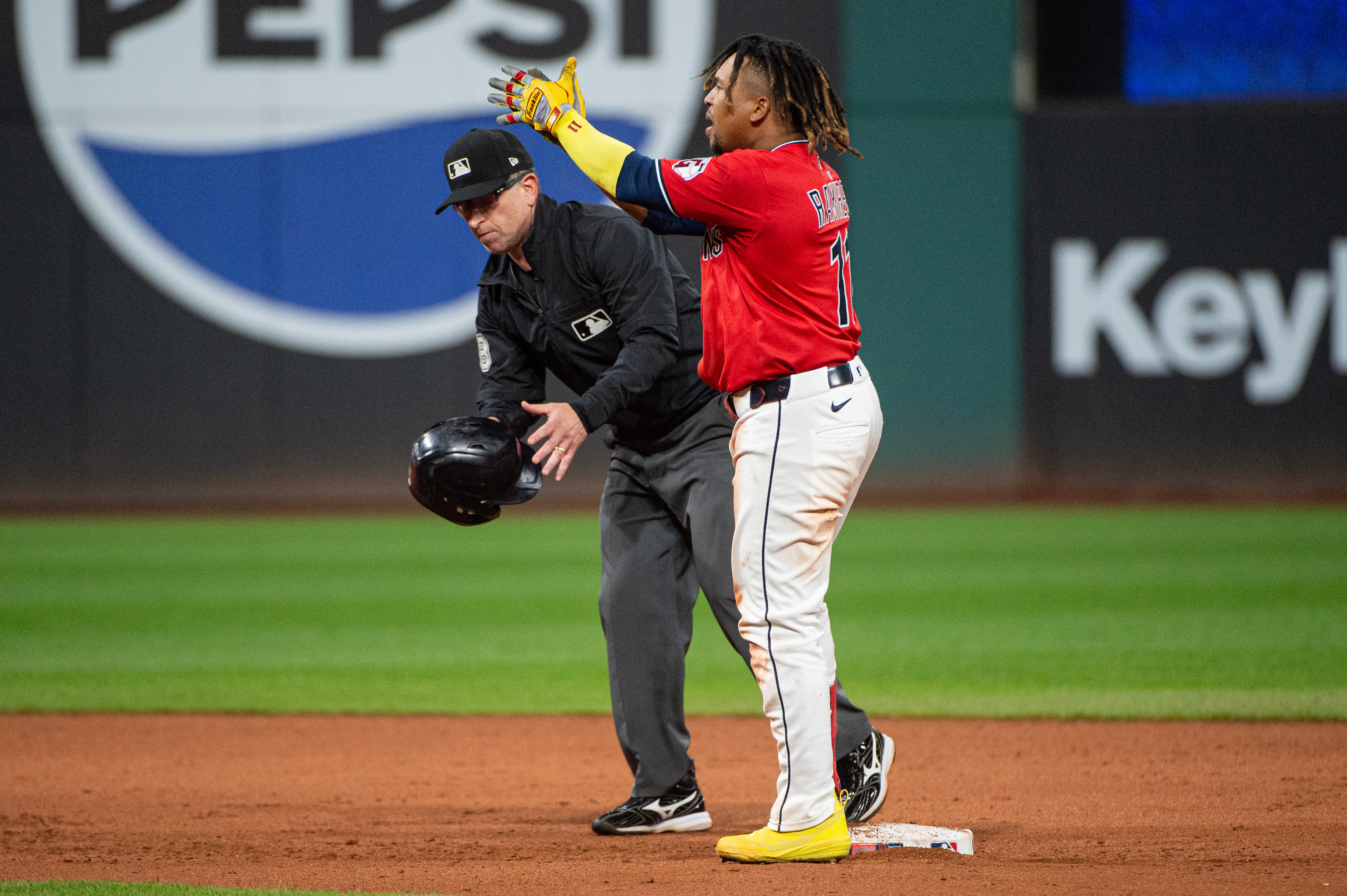 Cleveland Guardians' Jose Ramirez, right, reacts after hitting a two-run RBI double off Detroit Tigers relief pitcher Will Vest as umpire Chris Guccione, left, picks up his helmet during the seventh inning of a baseball game, Wednesday, Sept. 24, 2025, in Cleveland. 