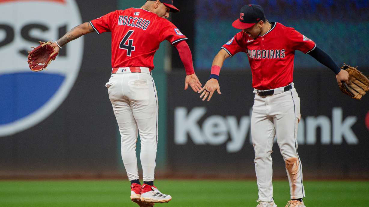 Cleveland Guardians' Brayan Rocchio (4) and Steven Kwan, right, celebrate at the end of a baseball game against the Detroit Tigers, Wednesday, Sept. 24, 2025, in Cleveland.