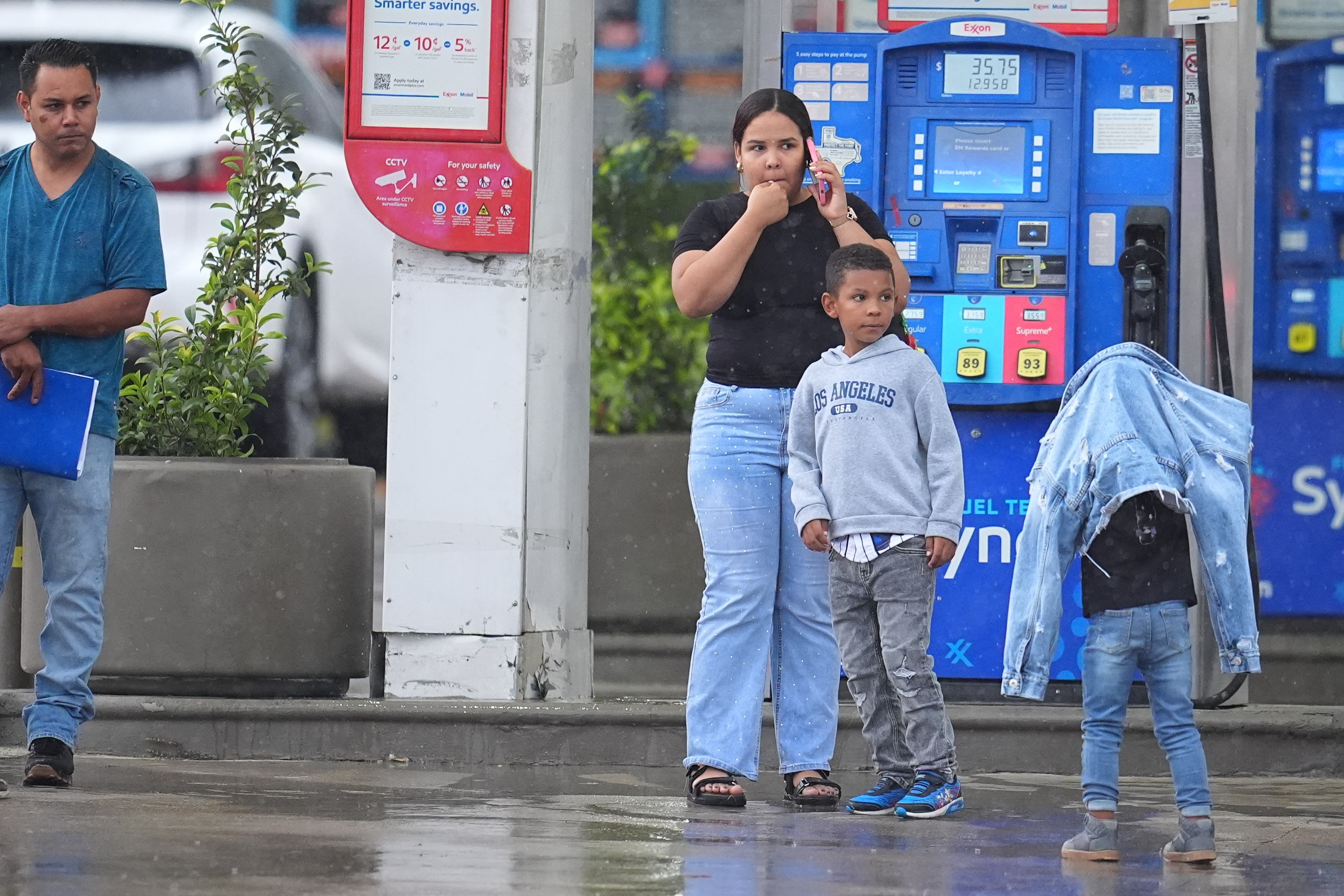 Edwin Cardona with his wife and sons on Wednesday, across from the U.S. Immigration and Customs Enforcement office in Dallas. Cardona had an appointment at the office when he first heard the gunshots.