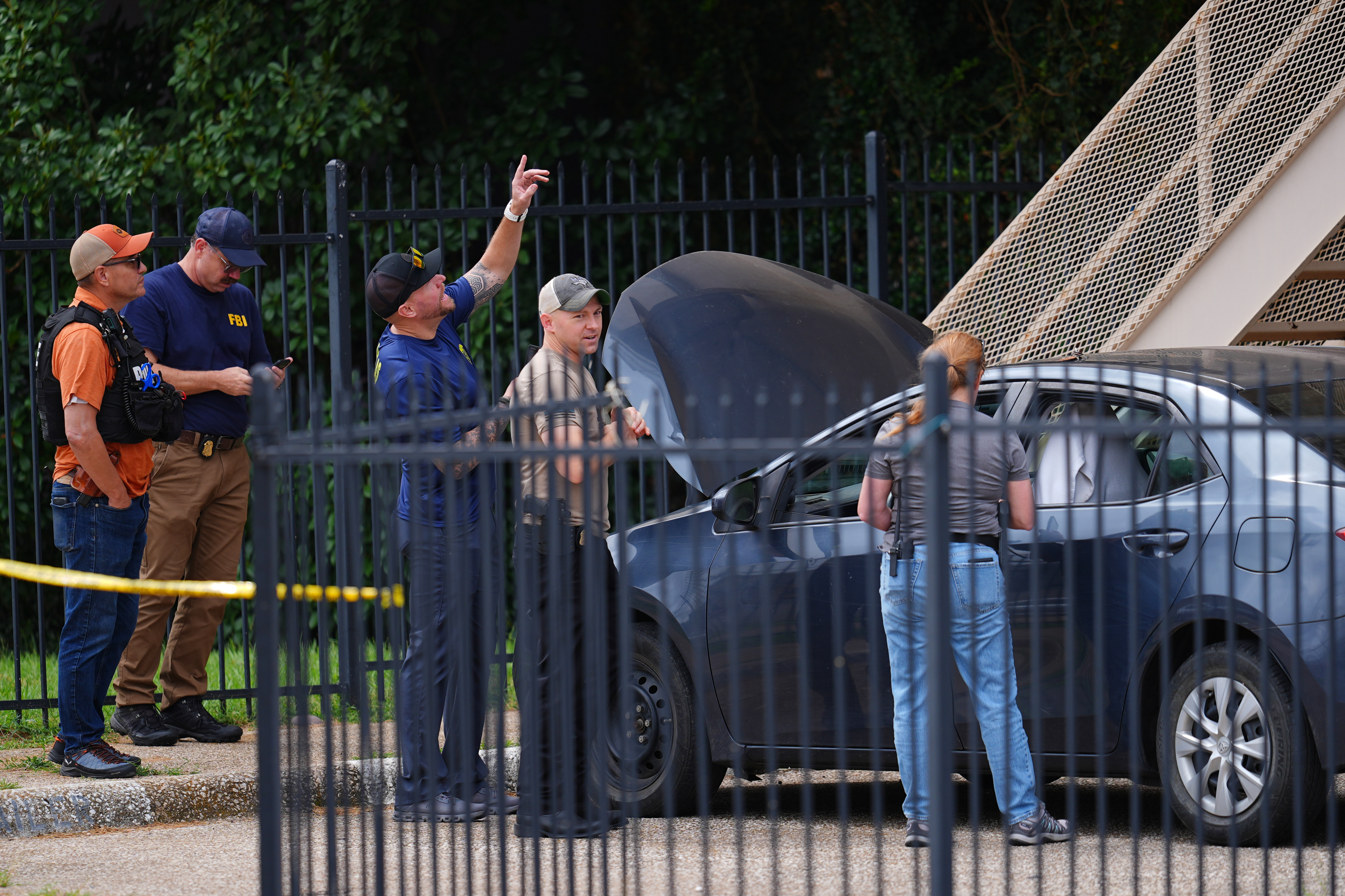 Law enforcement searches a vehicle in Dallas, Wednesday. The motive of a shooter who killed a detainee and critically wounded two others at an Immigrations and Customs Enforcement facility remained unclear Thursday.
