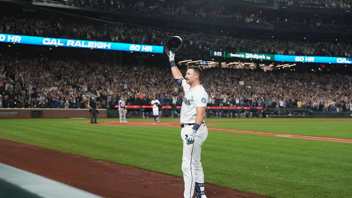Seattle Mariners' Cal Raleigh waves to the crowd after hitting his 60th home run during the eighth inning of a baseball game against the Colorado Rockies, Wednesday, Sept. 24, 2025, in Seattle.
