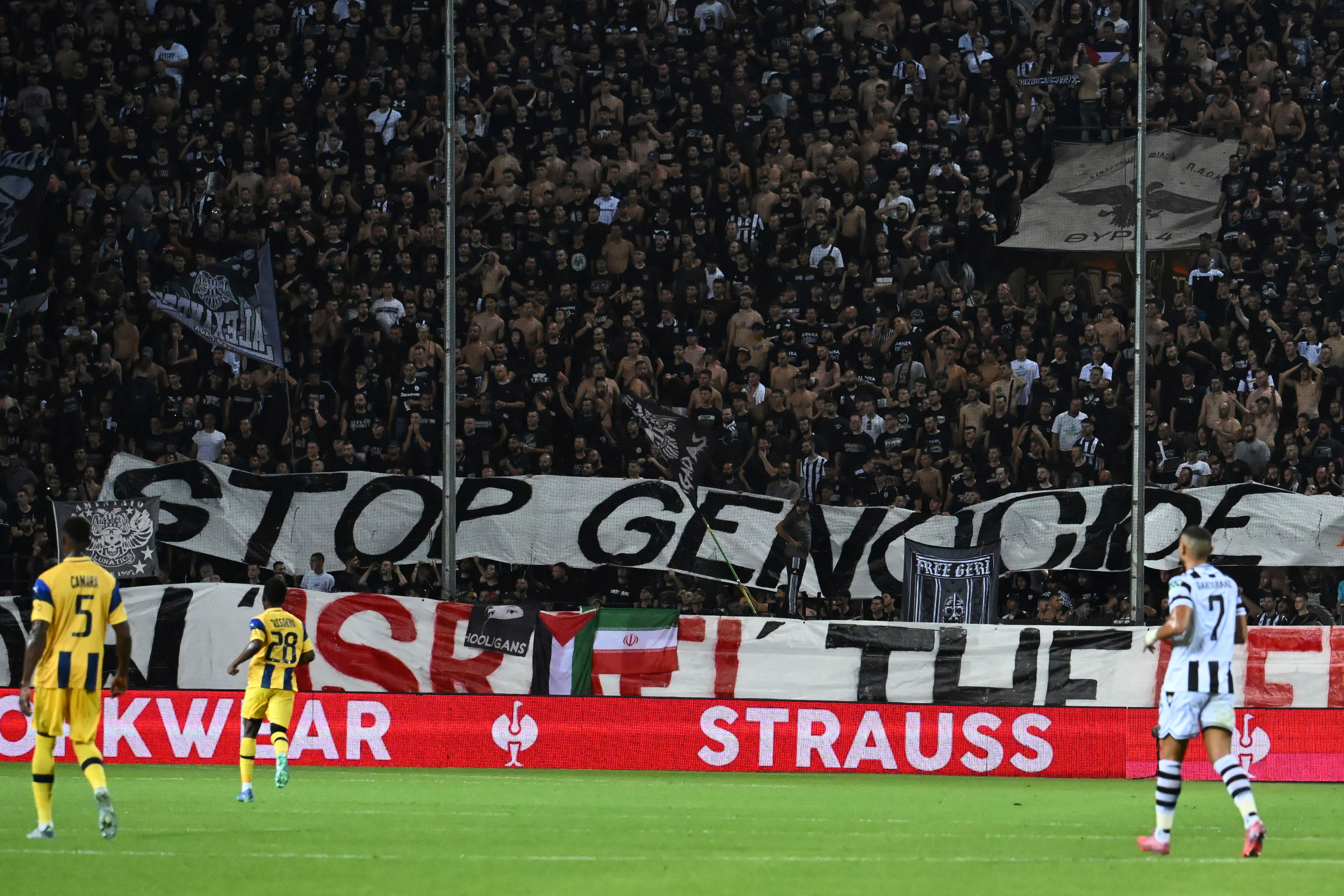 PAOK's fans display a banner that reads "stop genocide" during the Europa League soccer match between PAOK and Maccabi Tel Aviv at Toumpa stadium, in Thessaloniki, Greece, Wednesday, Sept. 24, 2025. 