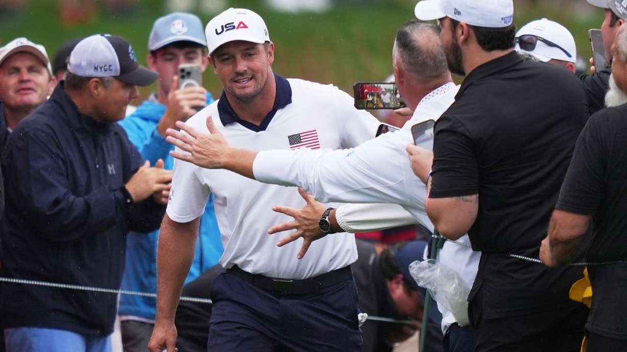 Fans greets United States' Bryson DeChambeau on the 17th hole during a practice round at the Ryder Cup golf tournament, Thursday, Sept. 25, 2025, on the Bethpage Black golf course, in Farmingdale, N.Y.