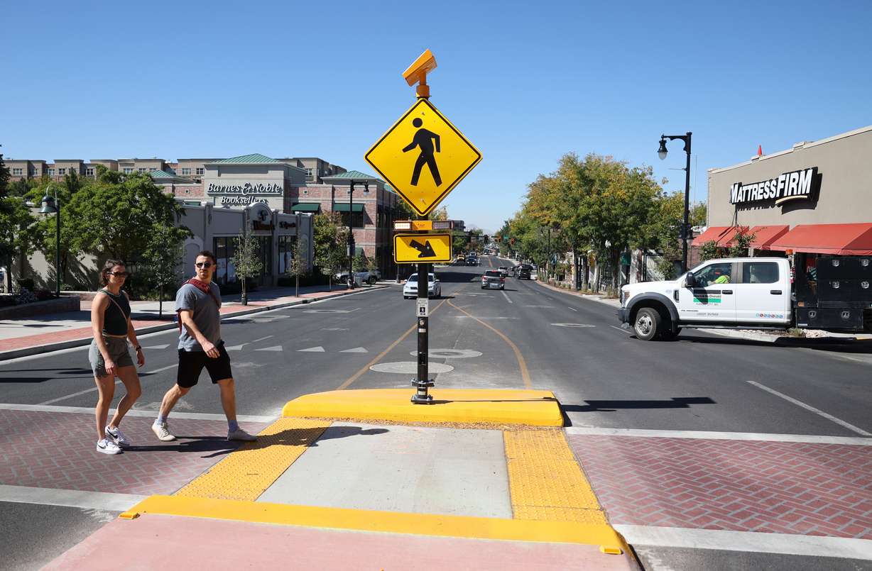 Pedestrians use a crosswalk to cross 2100 South in the Sugarhouse neighborhood of Salt Lake City on Thursday, Sept. 25, 2025.