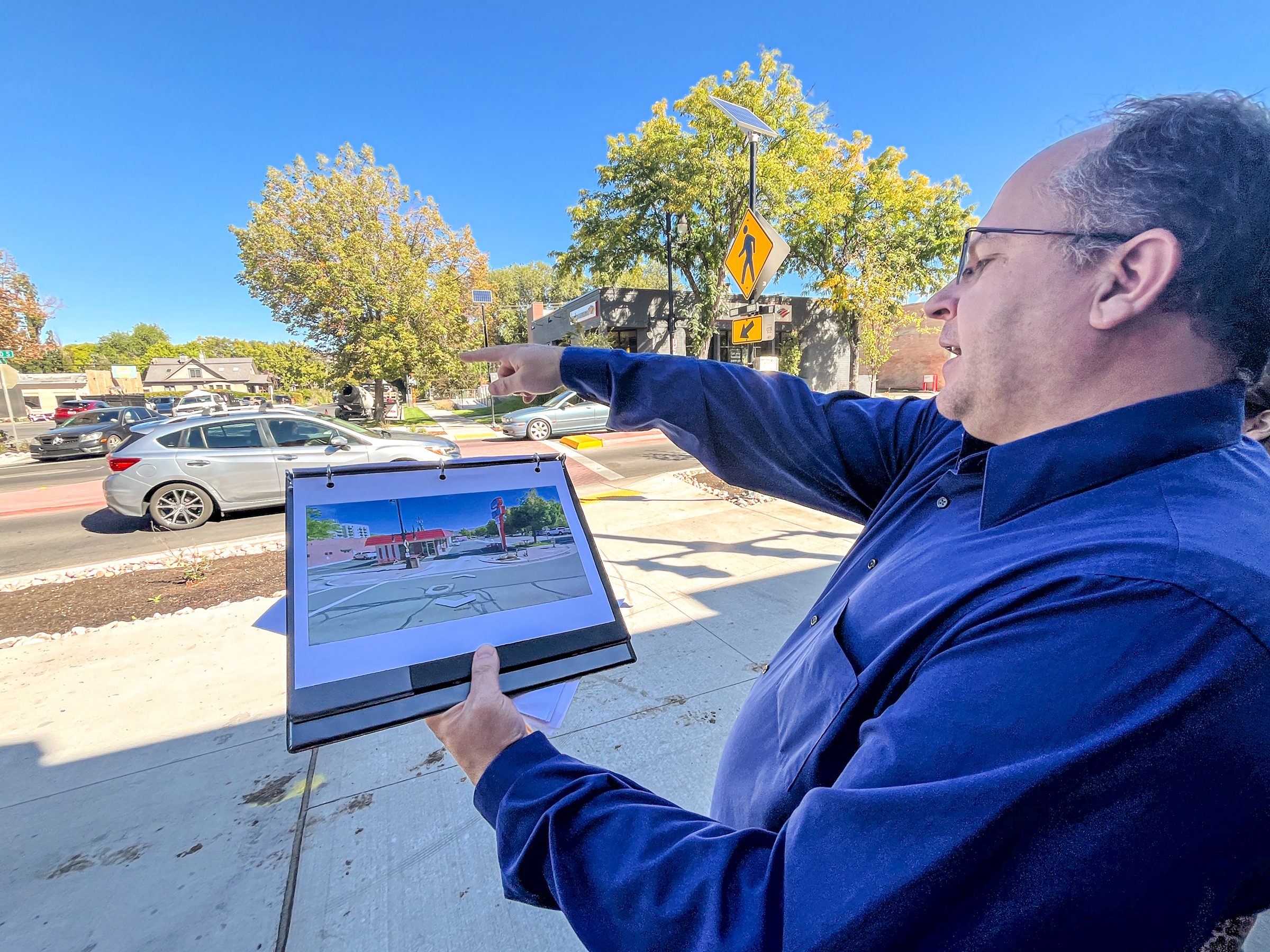 Lynn Jacobs, a project manager for Salt Lake City, points to a change on 2100 South near Millie's Burgers that was implemented based on feedback from the business during a tour of the changes in Salt Lake City's Sugar House neighborhood on Thursday. The project, he said, shifted a few times from business and motorist feedback.